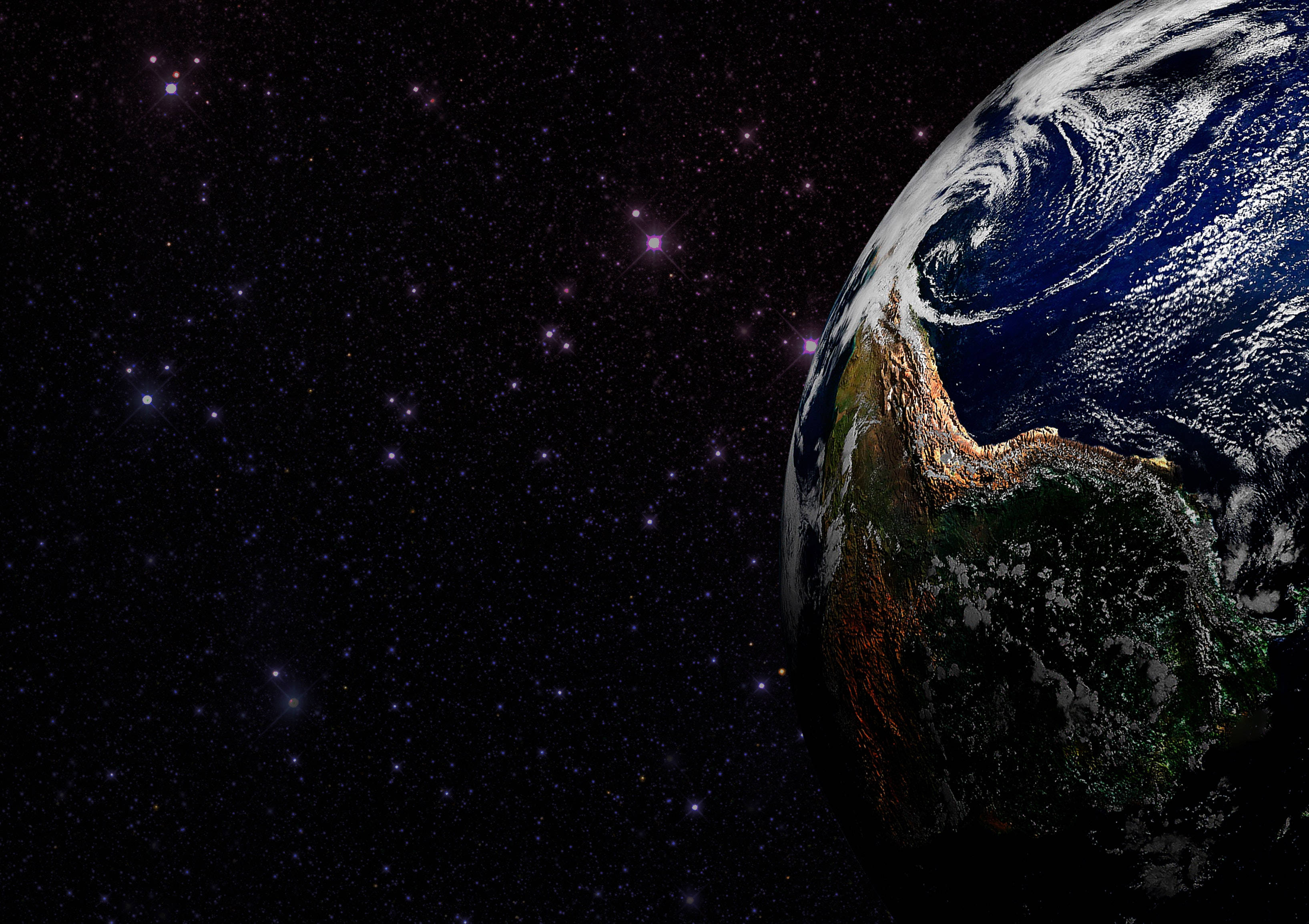 外太空 桌布 壁紙 — 從太空俯瞰地球的壯麗景色，展現出漩渦狀的雲層、海洋和大陸，背景是閃爍的星星。