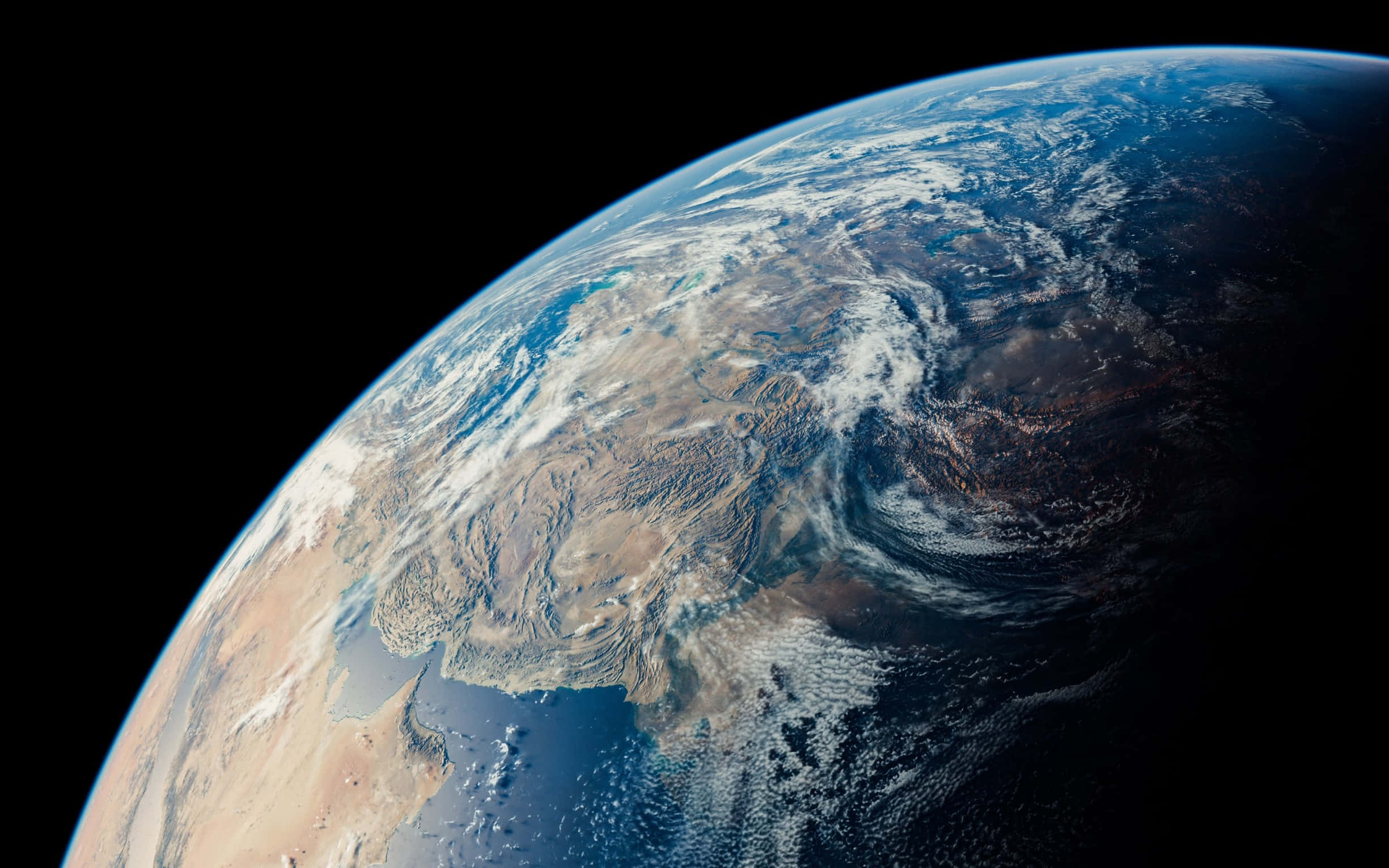 planet earth 桌布 壁紙 — 從太空俯瞰地球的壯麗景色，展現出大陸和海洋上空旋轉的雲層，映襯著黑色的虛空。