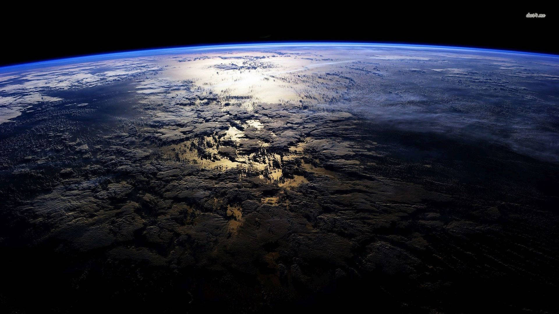 從太空看到的地球，帶有藍色大氣層和陽光照射的陸地。 — 4K 地球 壁紙
