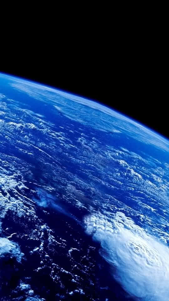 540x960 桌布 壁紙 — 從太空俯瞰地球的壯麗景色，展現出旋轉的藍色海洋、白雲和巨大的颶風。
