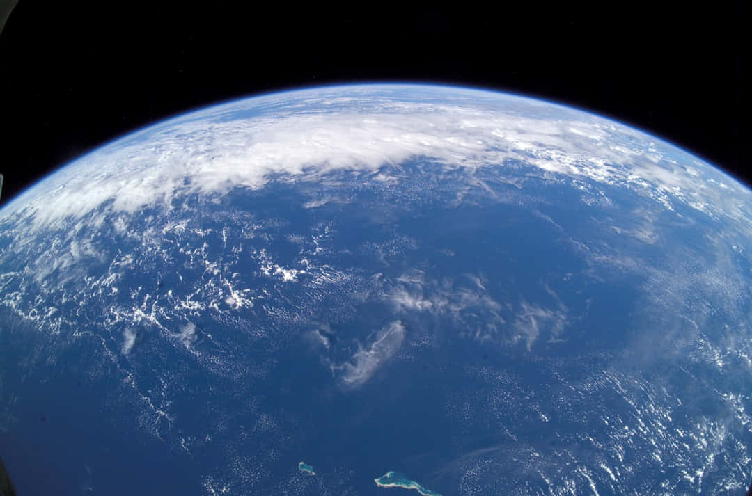 Blue Planet 桌布 壁紙 — 從太空俯瞰地球的壯麗景色，展現深藍色海洋上旋轉的白雲，以及黑色太空虛空中的彎曲地平線。