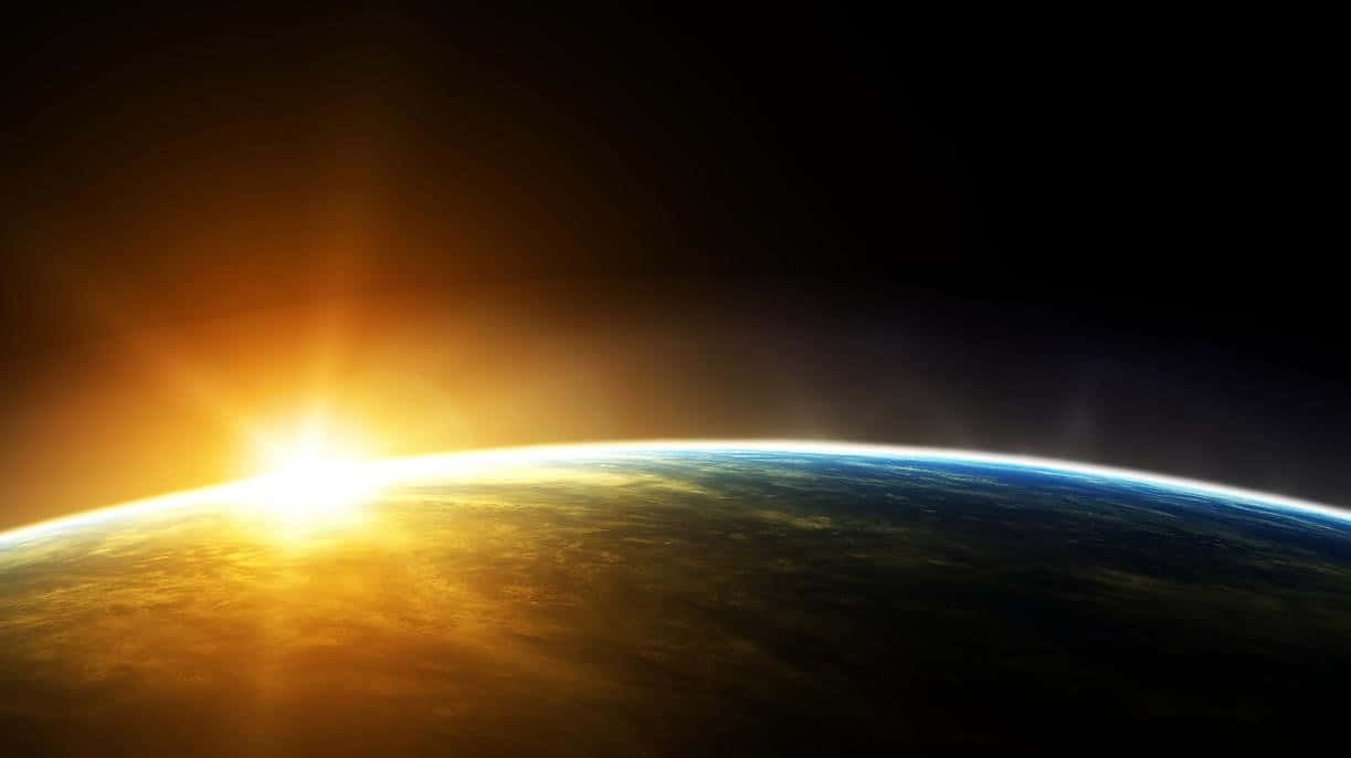 地球 桌布 壁紙 — 從太空看到地球的壯麗景色，太陽在彎曲的地平線上升起，將金色光芒灑向地球。