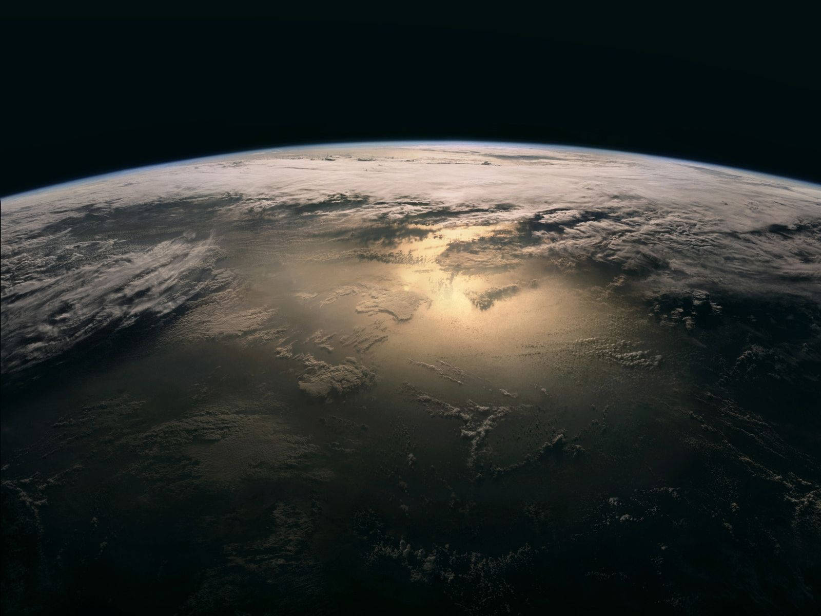NASA 動態圖片 桌布 壁紙 — 從太空觀看地球，金色陽光穿過彎曲地平線上的雲層。