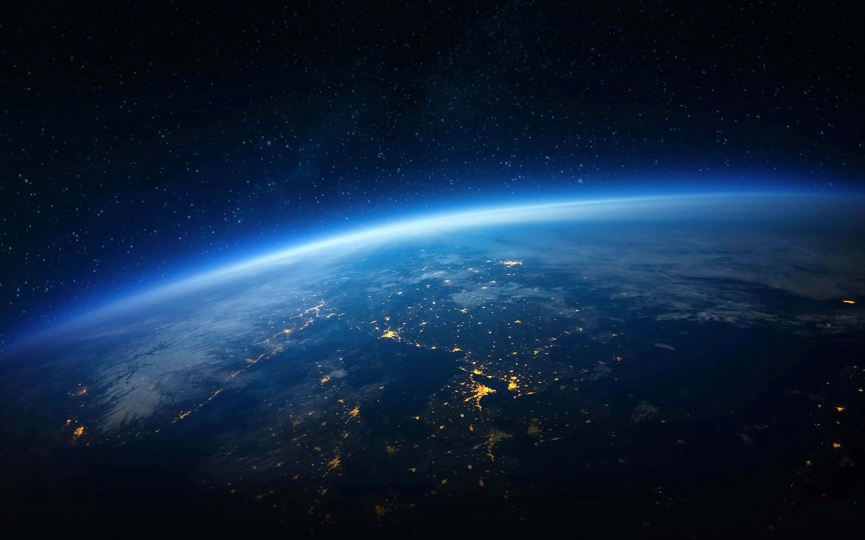宇宙 桌布 壁紙 — 從太空觀看夜晚的地球，城市燈光在繁星點點的黑色天空中閃耀。
