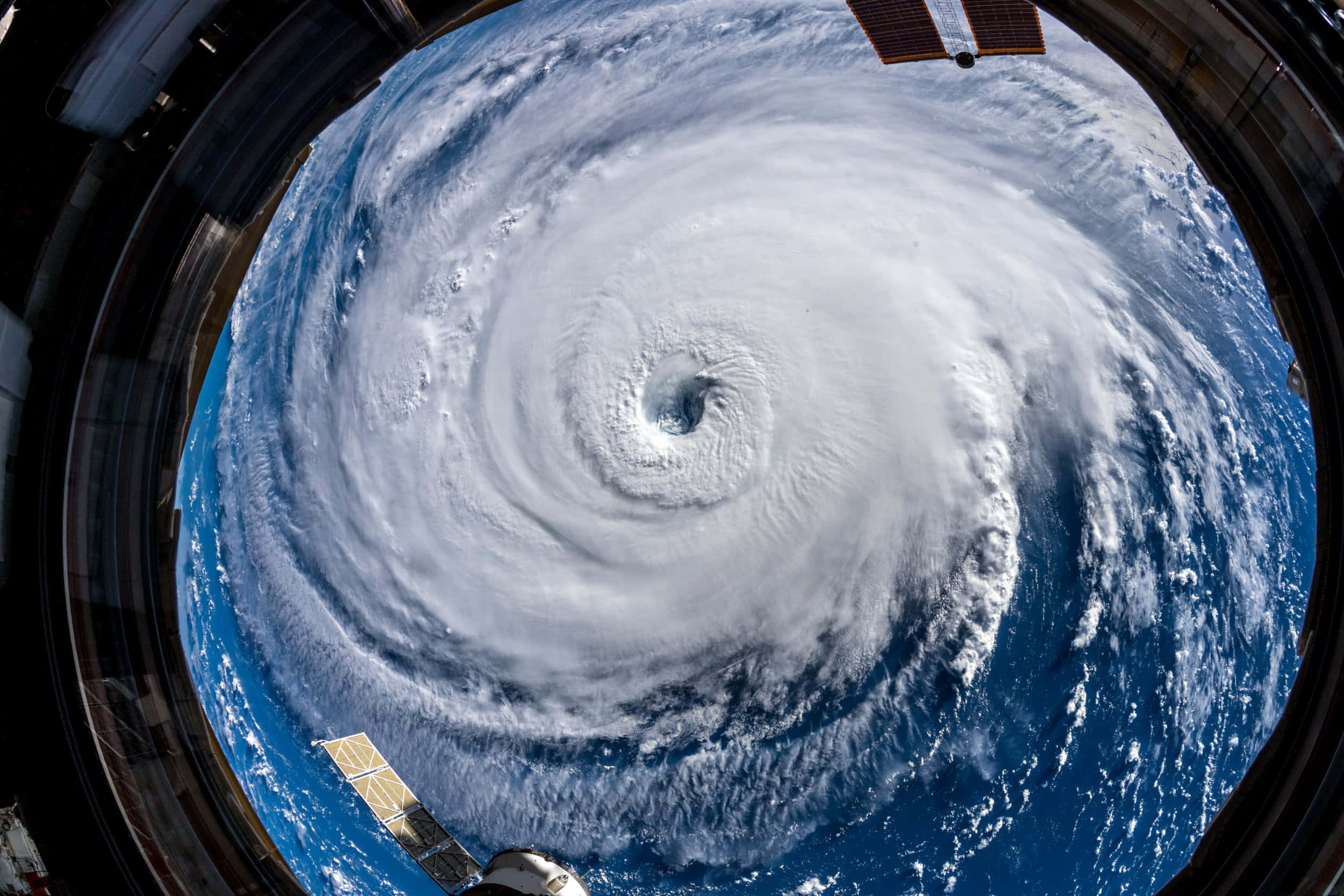 Hurricane 桌布 壁紙 — 從太空透過太空船窗戶看到的巨大颶風，太陽能板清晰可見。