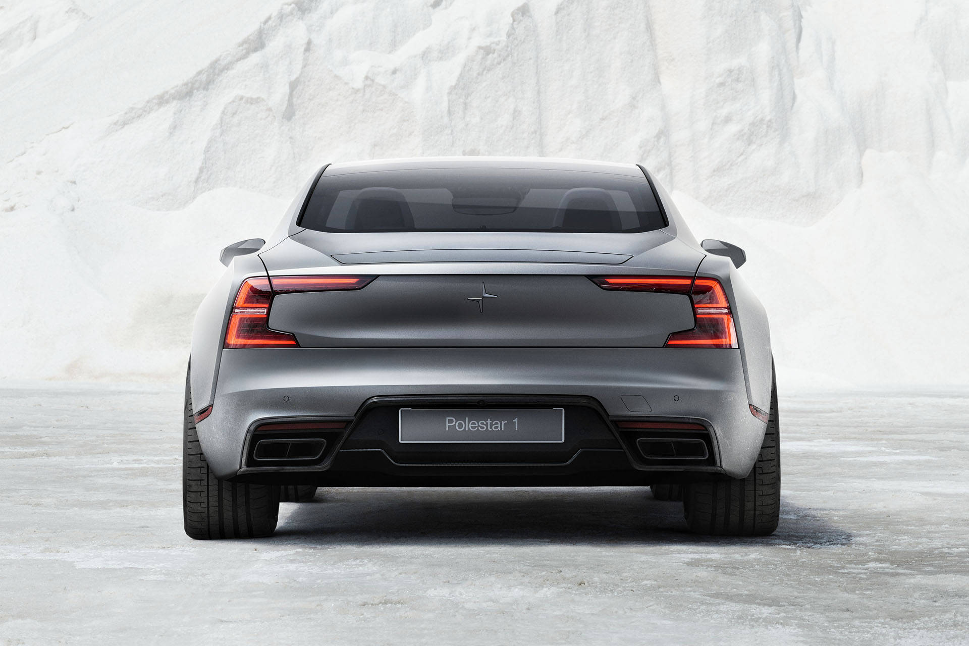 豪華車 桌布 壁紙 — 從後方看到的時尚銀色Polestar 1跑車，停在結冰的地面上，背景是白雪覆蓋的懸崖。
