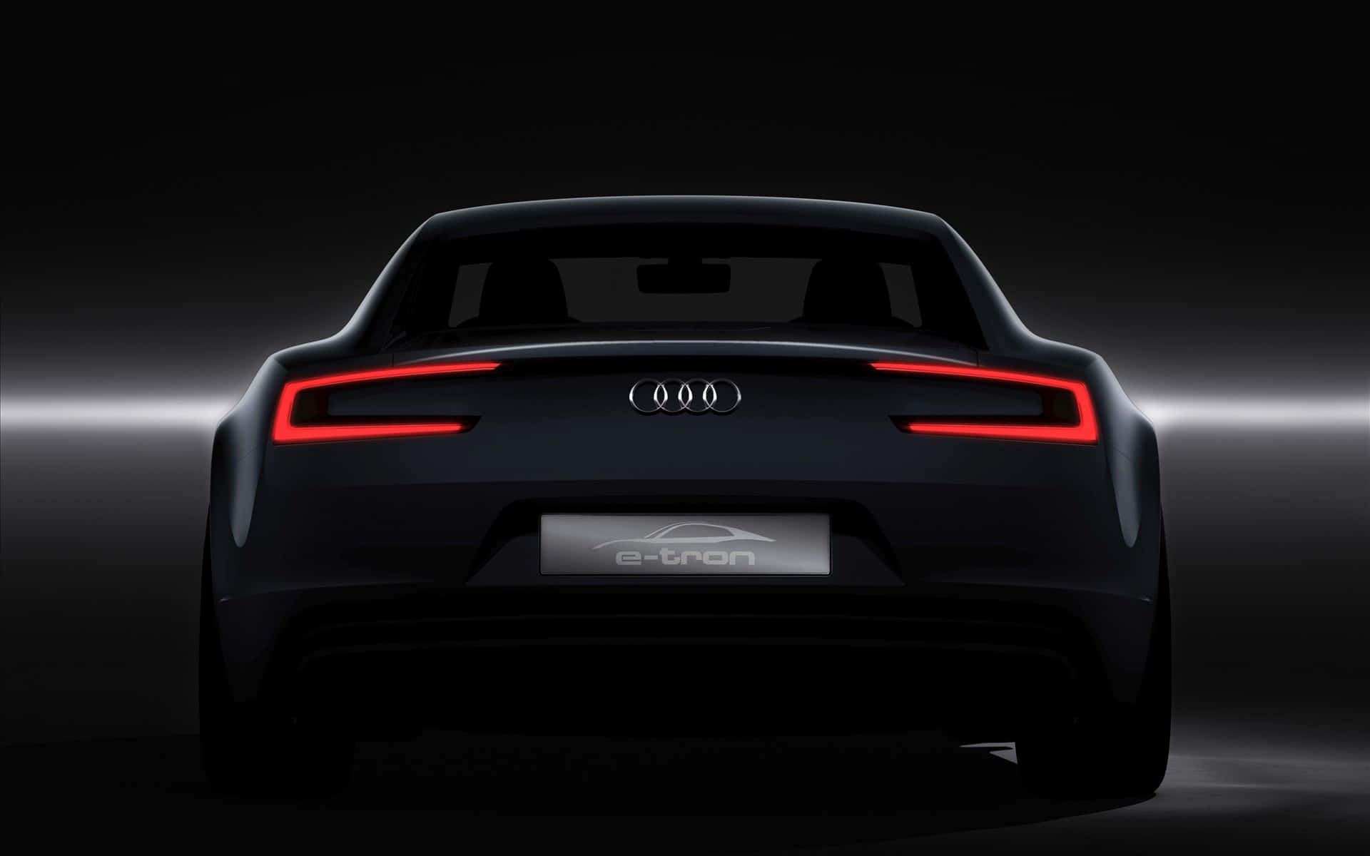 奧迪 桌布 壁紙 — 從後方觀看，一輛時尚黑色Audi e-tron跑車，在黑暗的攝影棚背景下帶有發光的紅色尾燈。