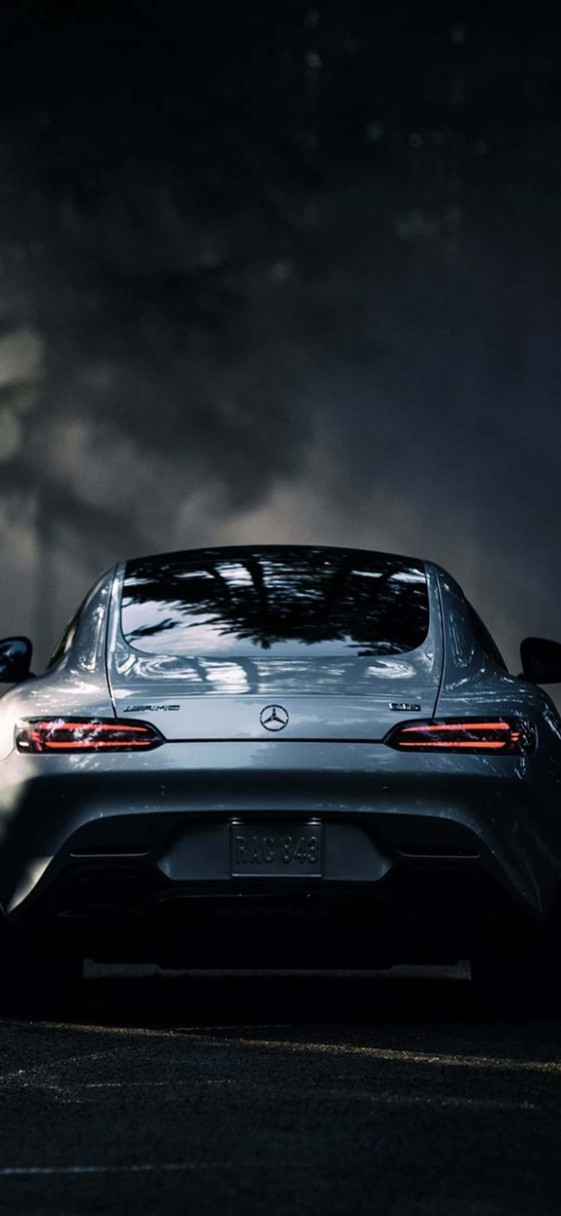 Mercedes 桌布 壁紙 — 從後方觀看，在戲劇性的夜間燈光下，煙霧繚繞的銀色賓士AMG GT R跑車。