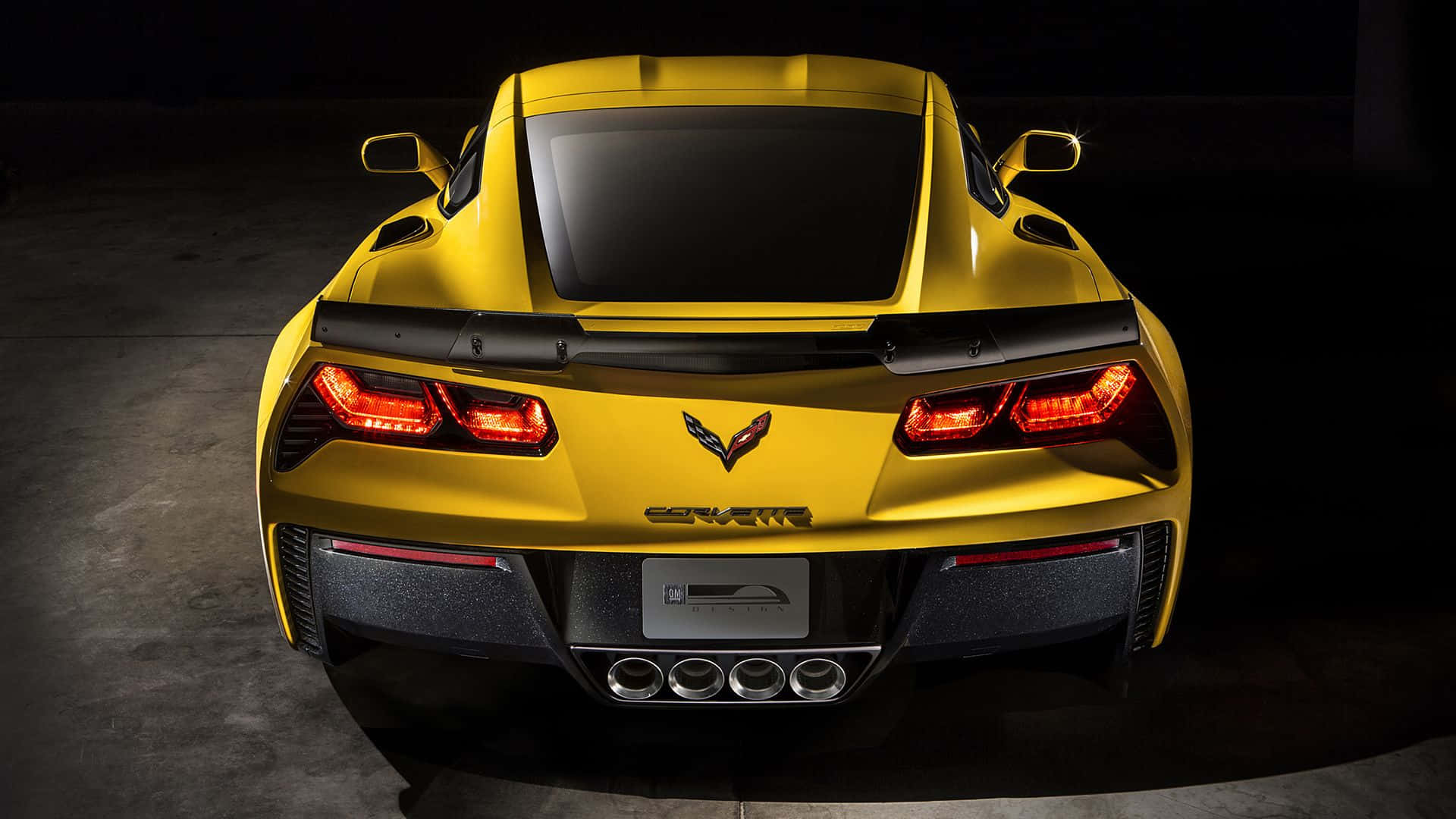 Chevrolet Corvette Z06 桌布 壁紙 — 從後方觀看一輛充滿活力的黃色雪佛蘭Corvette跑車，紅色尾燈在黑暗的攝影棚背景中發光。