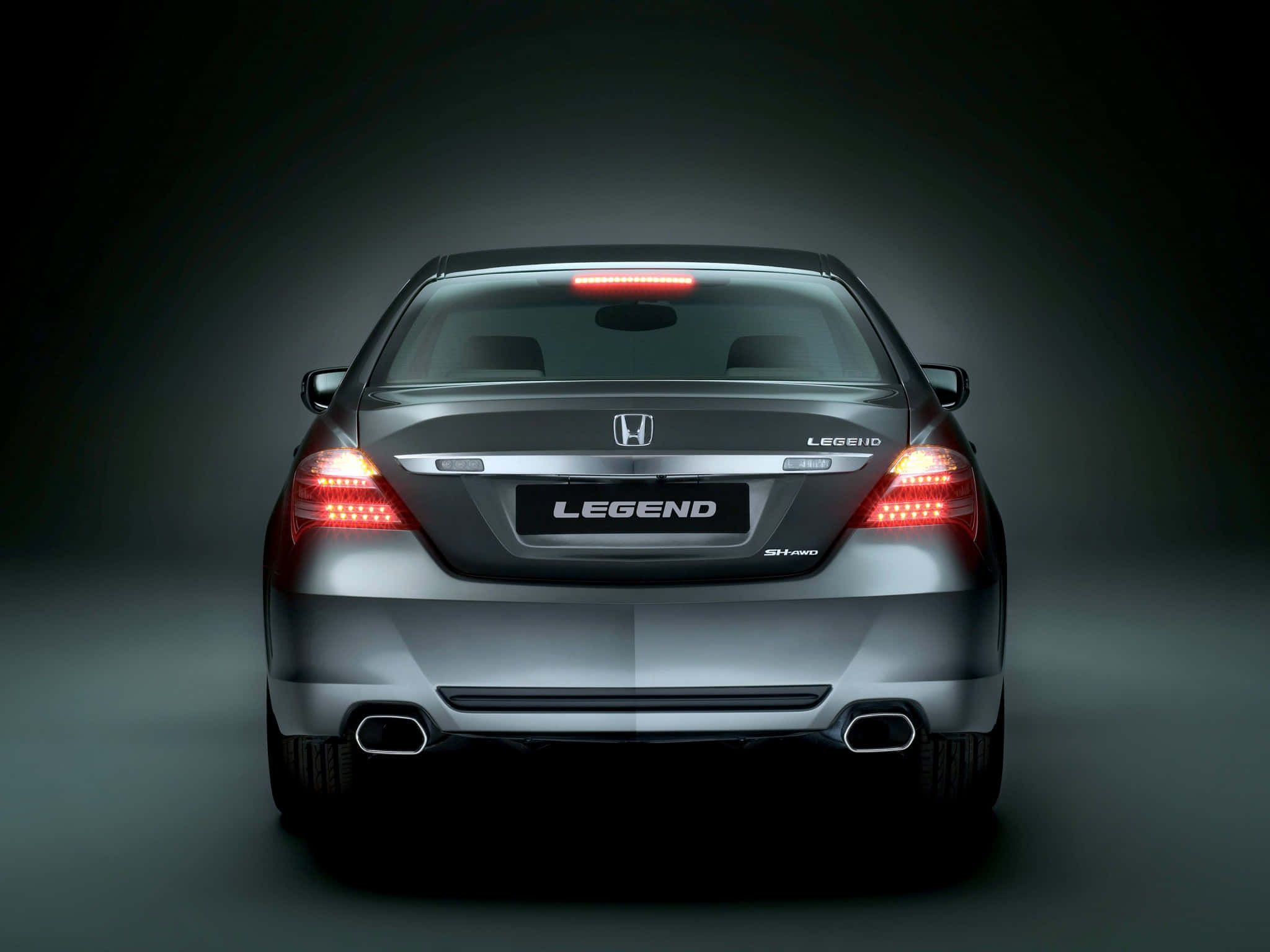 Honda Legend 桌布 壁紙 — 從後方觀看一輛時尚的銀色本田Legend轎車，紅色尾燈在黑暗的攝影棚背景下發光。