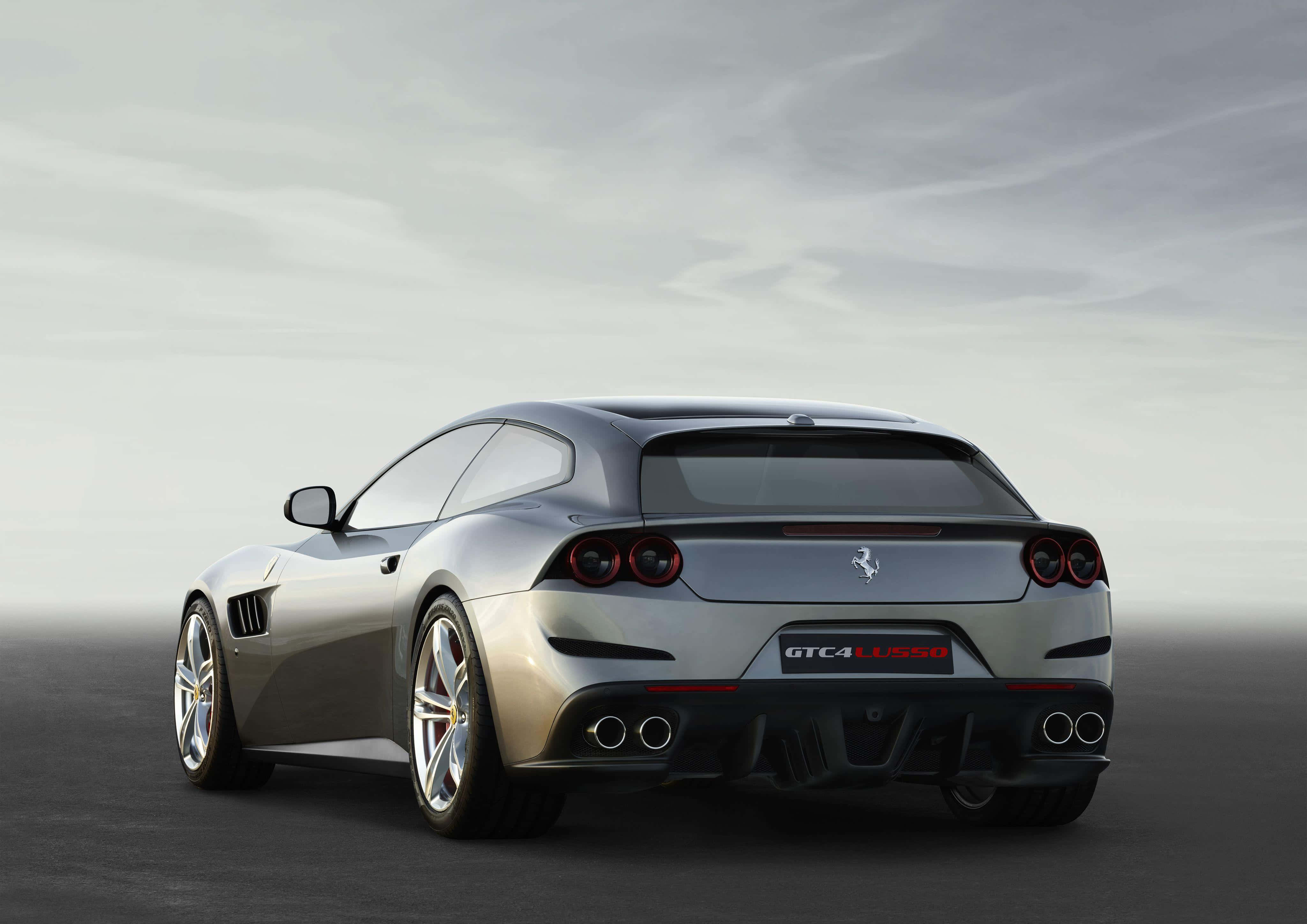 Ferrari Gtc4lusso 桌布 壁紙 — 從後方觀看一輛時尚的銀色法拉利 GTC4Lusso 跑車，背景是簡約的灰色天空和道路。