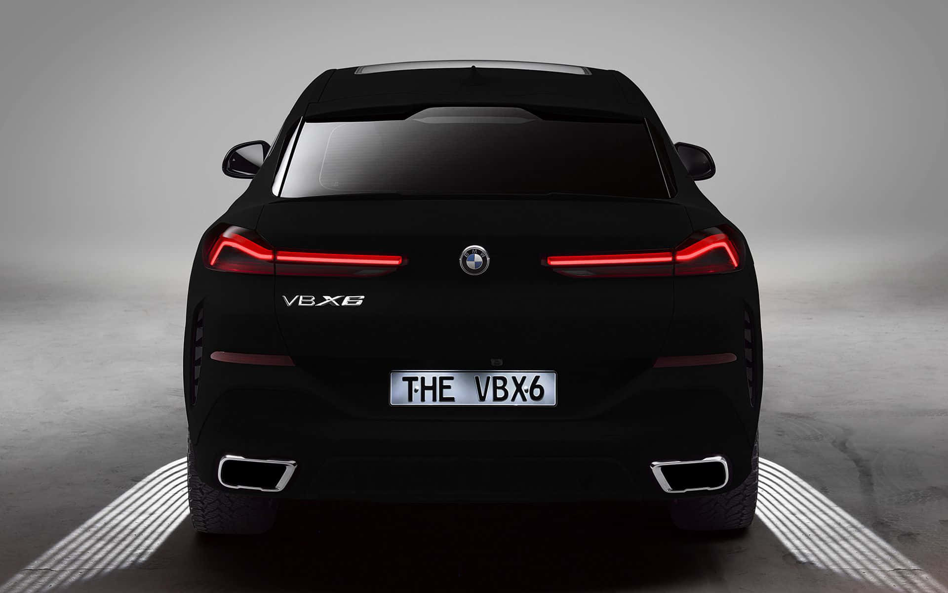 Vantablack 桌布 壁紙 — 從後方觀看一輛時尚的黑色BMW VBX6，在簡約的攝影棚地板上，帶有發光的紅色尾燈和照明輪拱。