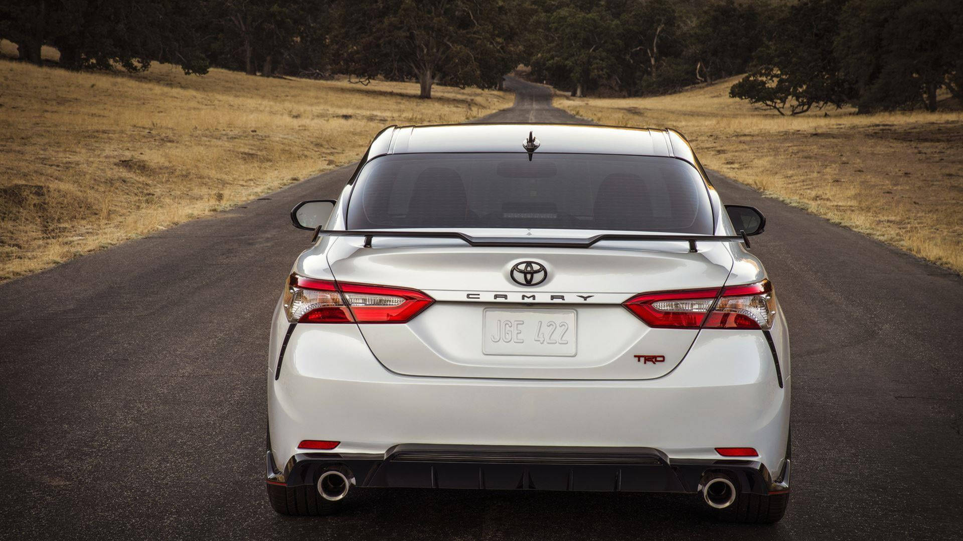 白色豐田Camry TRD房車在日落時分行駛在鄉村道路上。 — Toyota Supra Mk4 壁紙