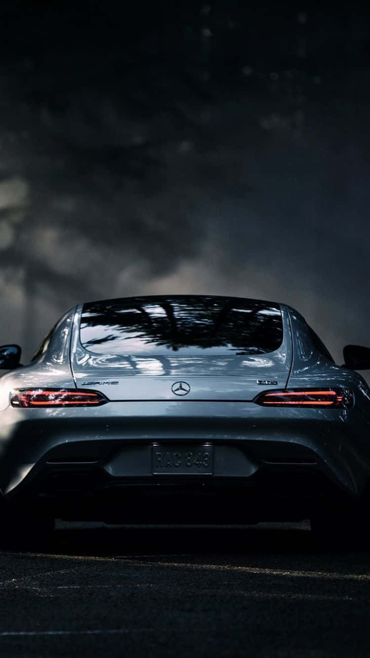 Mercedes 桌布 壁紙 — 從後方觀看的時尚銀色 Mercedes-AMG 跑車，紅色尾燈在黑暗煙霧背景下發光。
