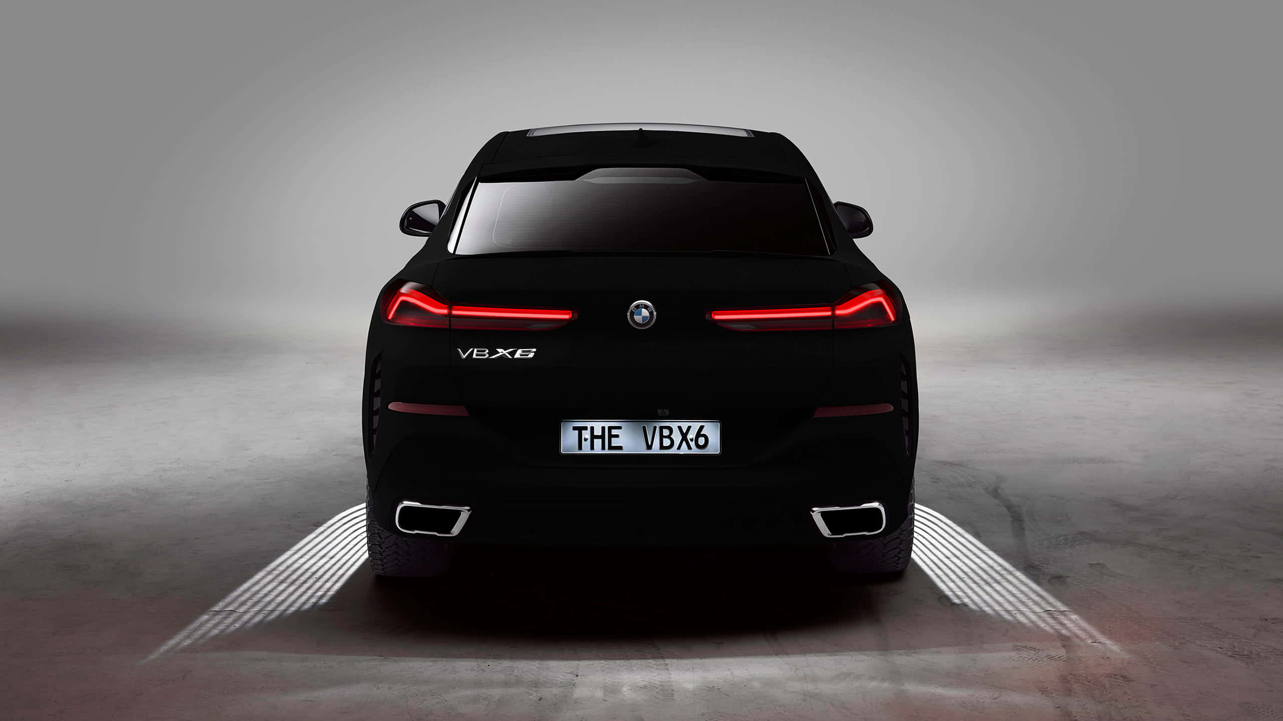 Vantablack 桌布 壁紙 — 從後方觀看的時尚黑色BMW V8X6跑車，帶有發光的紅色尾燈和照明地面圖案，在簡約的攝影棚環境中。