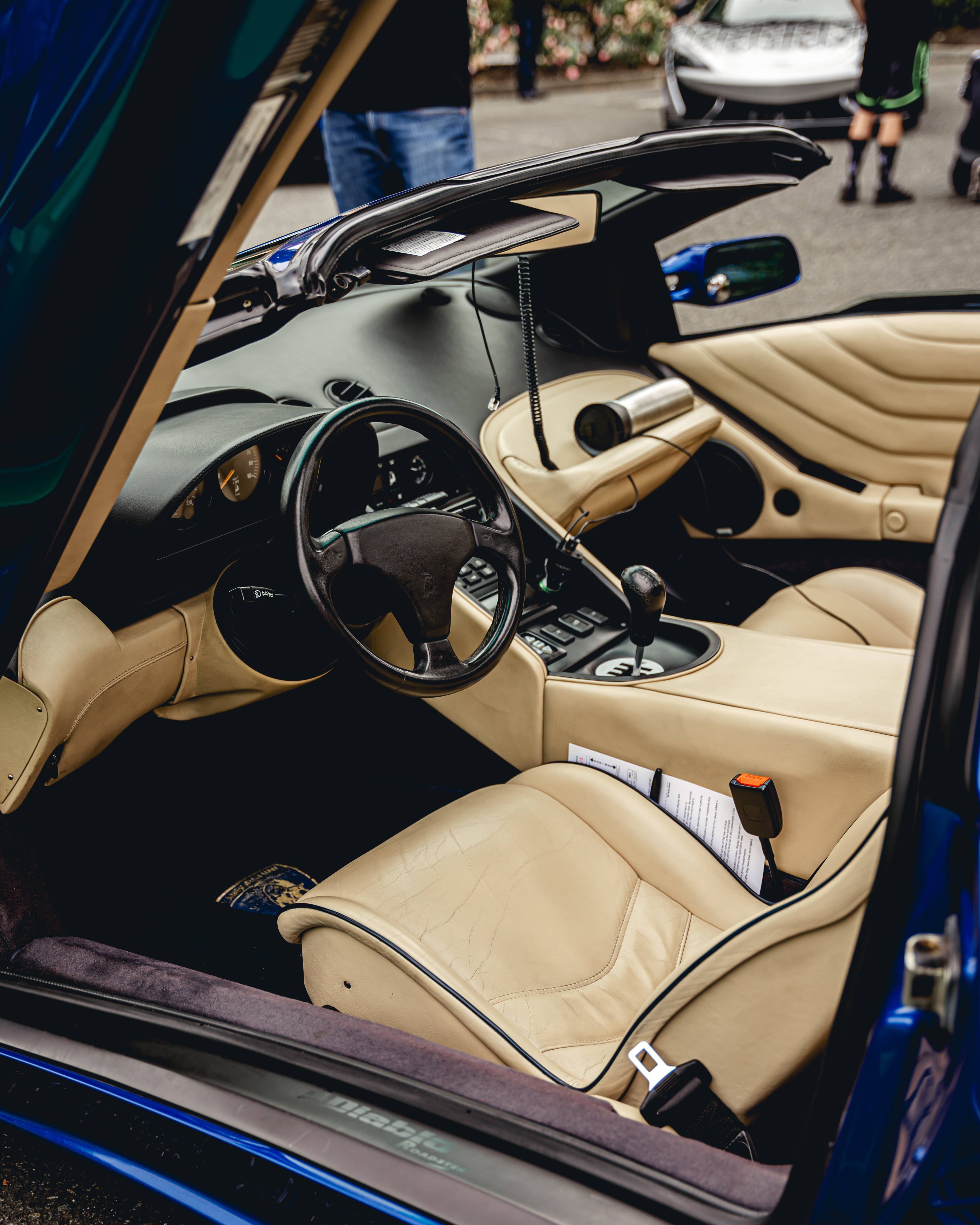 4K Lamborghini 桌布 壁紙 — 從打開的車門看到的豪華跑車內裝，配有米色皮革座椅和黑色儀表板。