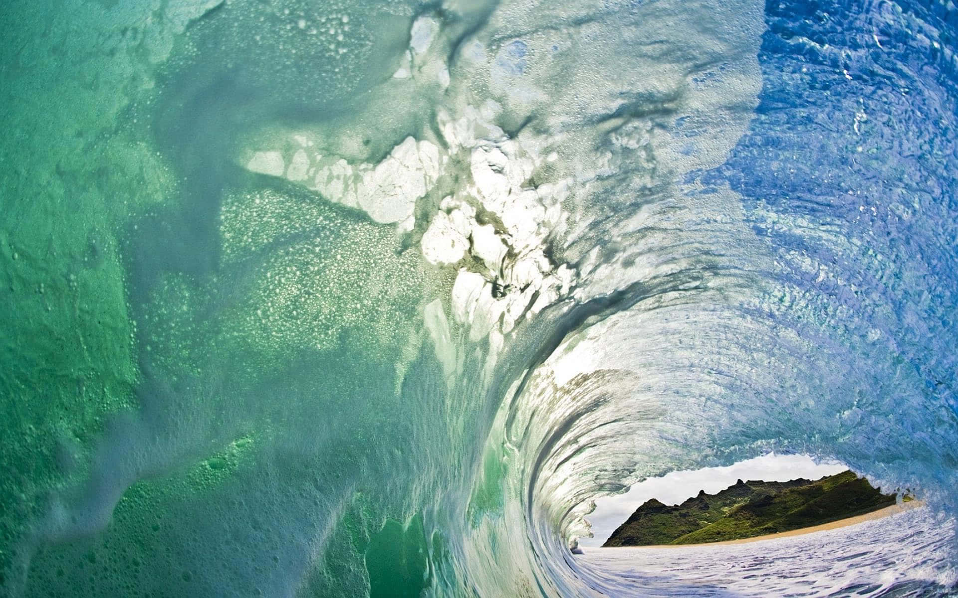 waves 桌布 壁紙 — 從捲曲的海浪內部看到的驚人水下景觀，露出遠處的岩石海岸。