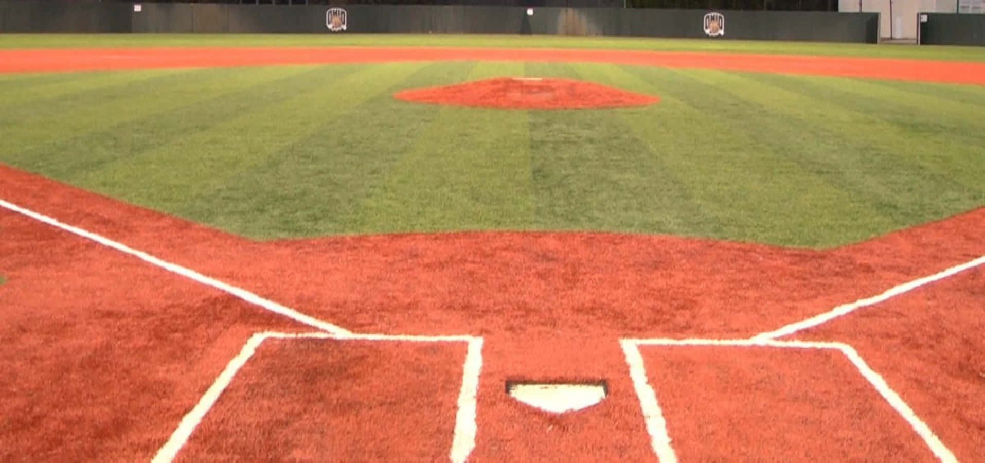 Baseball Field 桌布 壁紙 — 從本壘板觀看的純淨棒球場，在鮮紅的泥土和茂密的綠草上顯示出清晰的白色粉筆線。