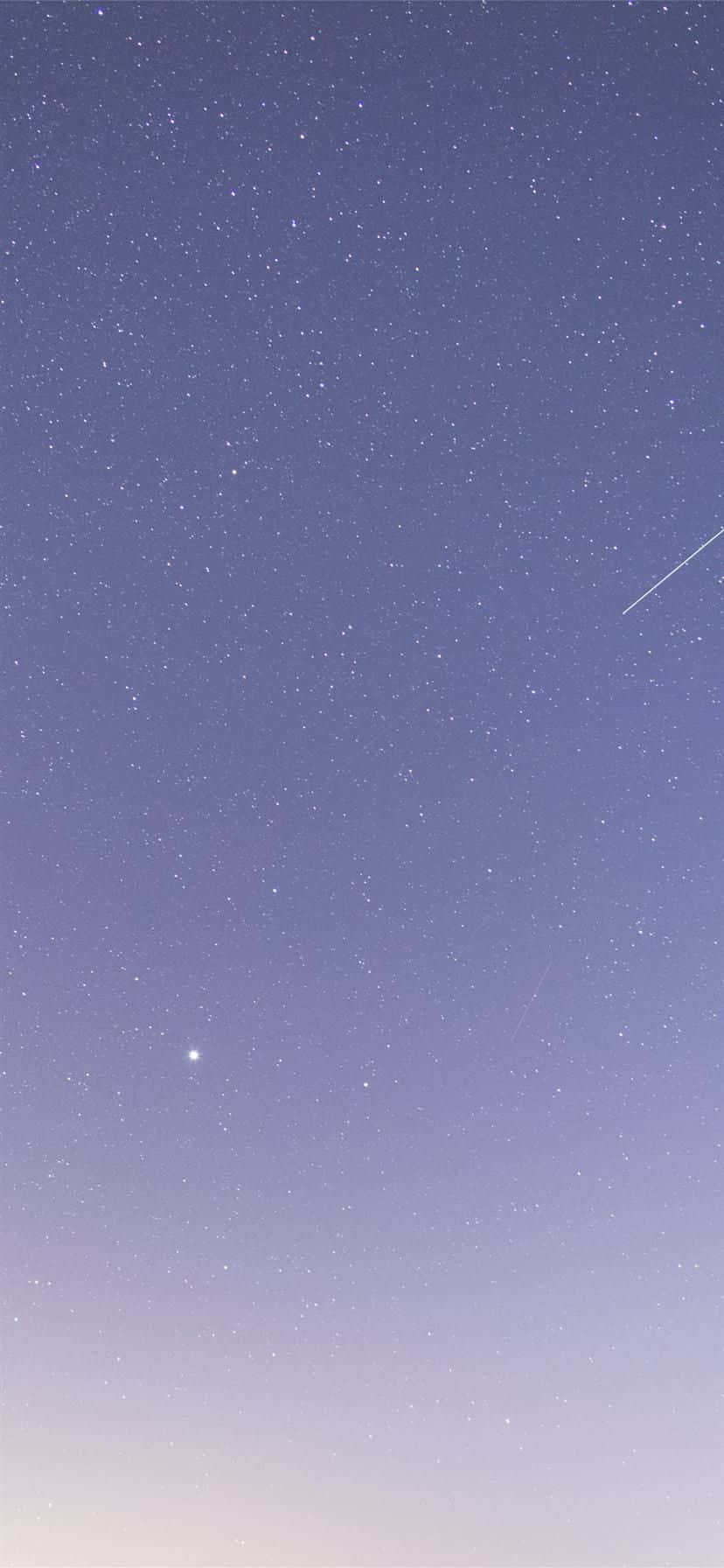 桌布 壁紙 — 從深紫色到柔和薰衣草的寧靜夜空漸變，點綴著無數星星和一顆明亮的流星斜斜劃過。