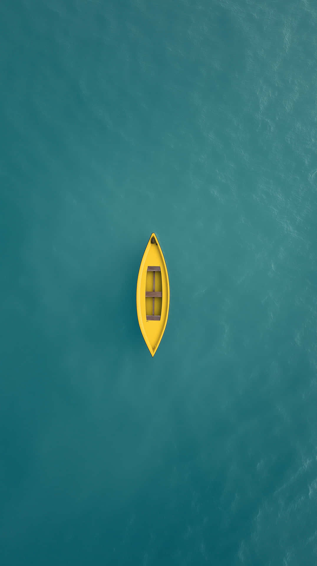 Empty Yellow Gondola Boat Adrift in Serene Open Water with Fish 壁紙 — 從無人機俯瞰視角，一艘亮黃色的獨木舟獨自漂浮在平靜的碧綠水面上。