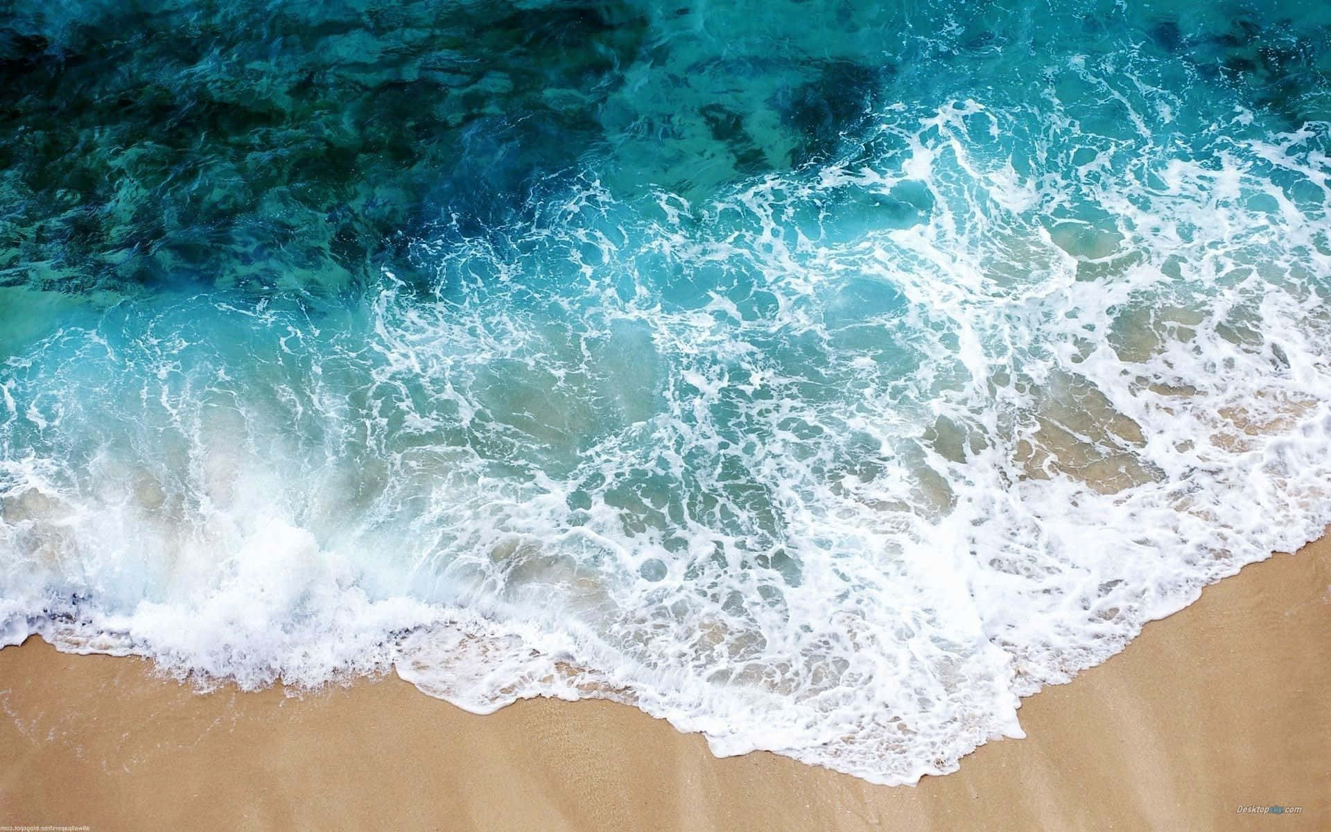 夏日美學動畫 桌布 壁紙 — 從空中俯瞰，綠松石色的海浪拍打著金色沙灘，泛起白色泡沫。