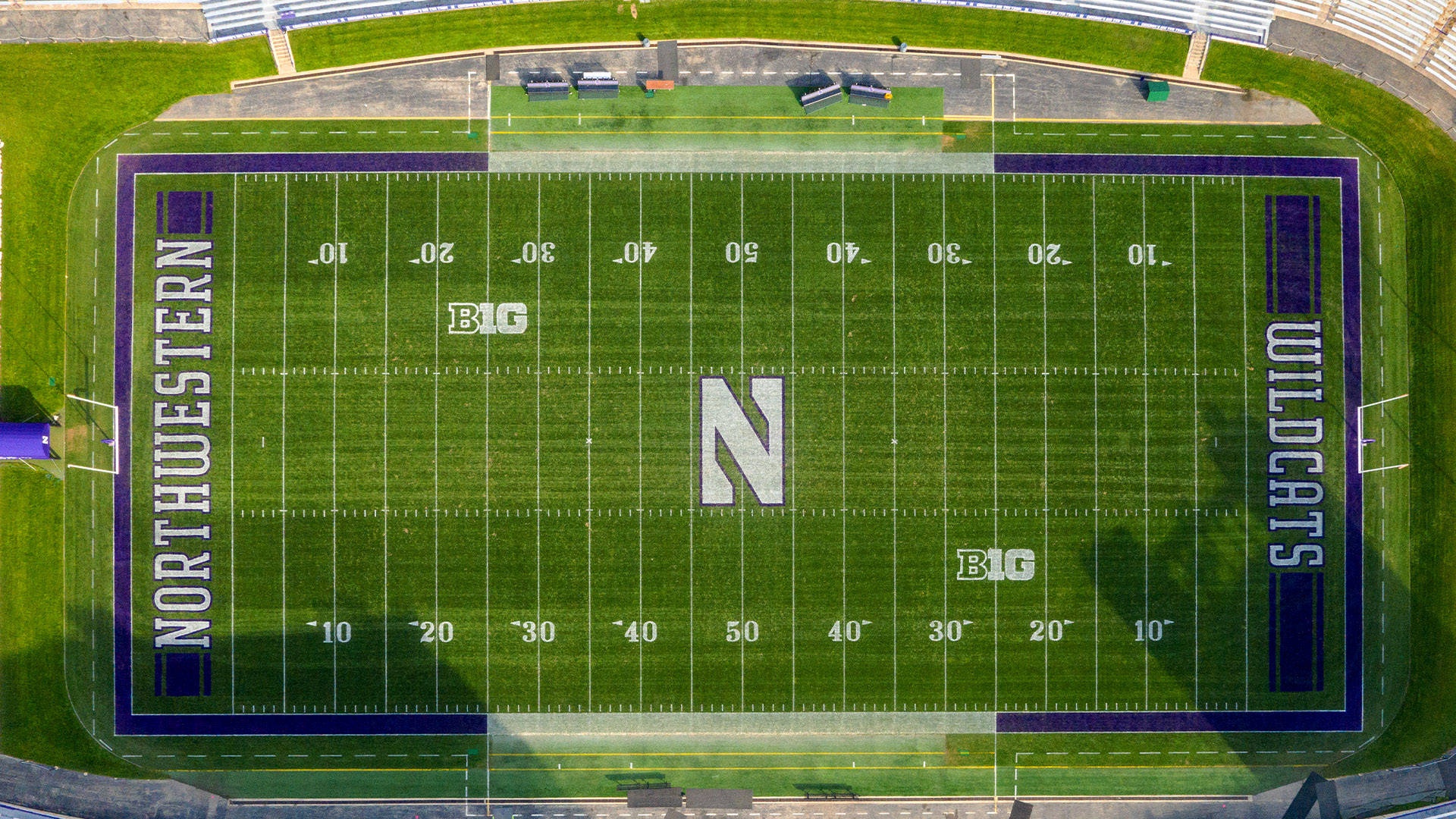 運動 桌布 壁紙 — 從空中俯瞰一個充滿活力的綠色足球場，上面有「NORTHWESTERN WILDCATS」和一個大型的「N」標誌。