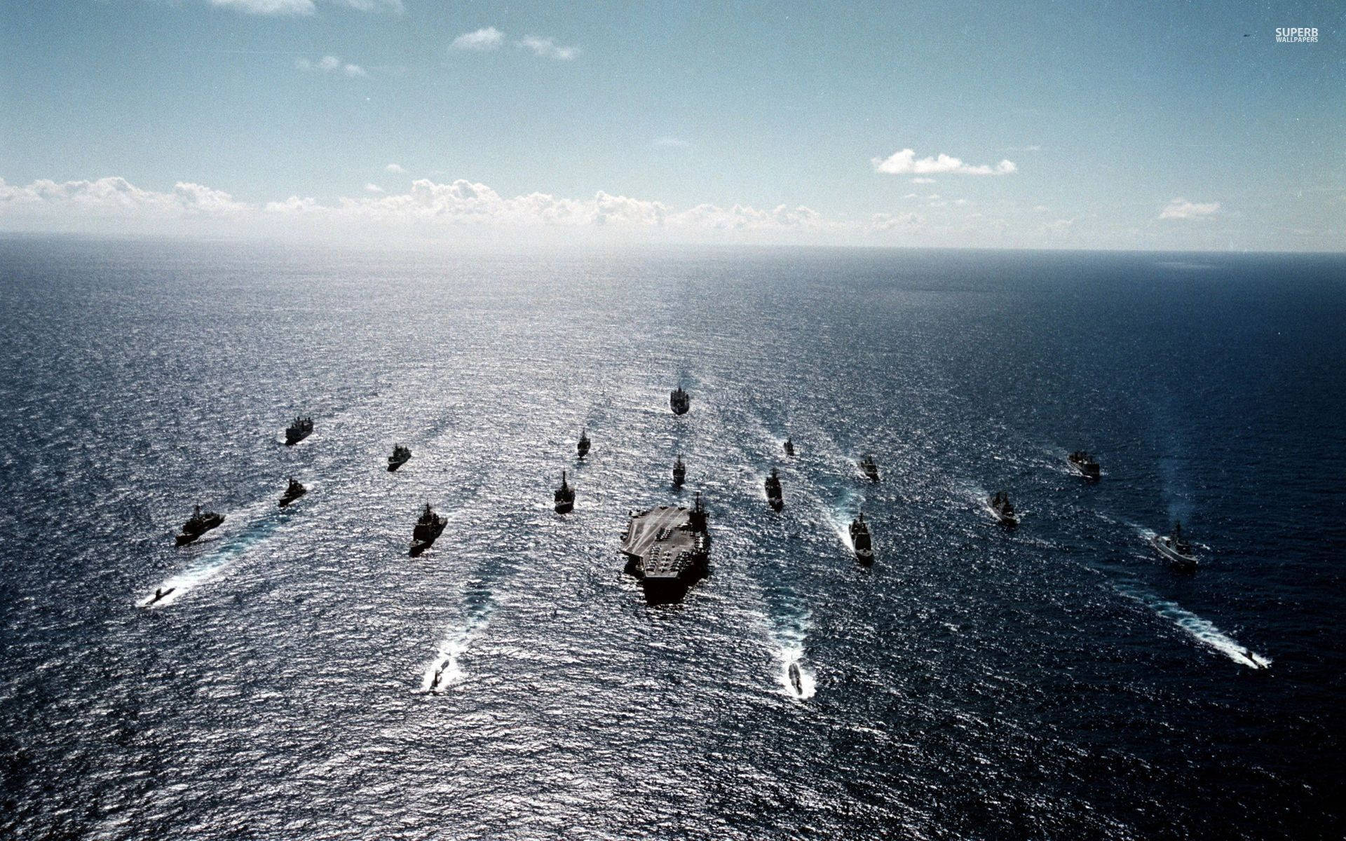 日落時分，航空母艦率領海軍艦隊在開闊的海洋中航行。