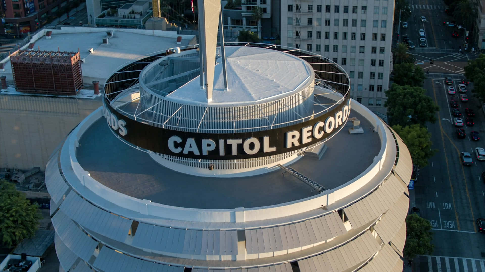 top 桌布 壁紙 — 從空中俯瞰標誌性的 Capitol Records 大樓，其圓形設計和「CAPITOL RECORDS」標誌在金色陽光下閃耀。