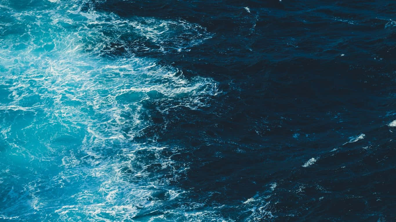 Sea 桌布 壁紙 — 從空中俯瞰湍急的海浪，帶有泡沫般的藍綠色痕跡劃過深藍色的海水。