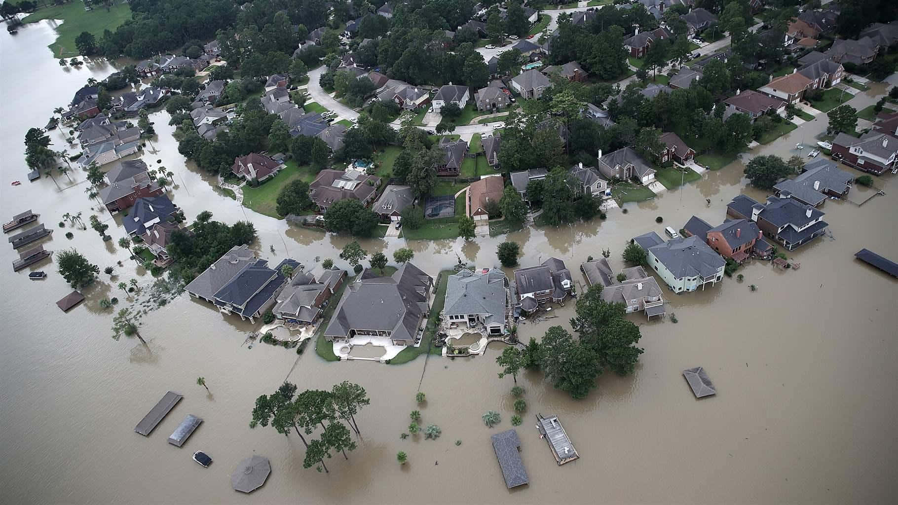 Flood 桌布 壁紙 — 從空中俯瞰郊區房屋淹沒在泥濘的洪水中，樹木和街道幾乎看不見。