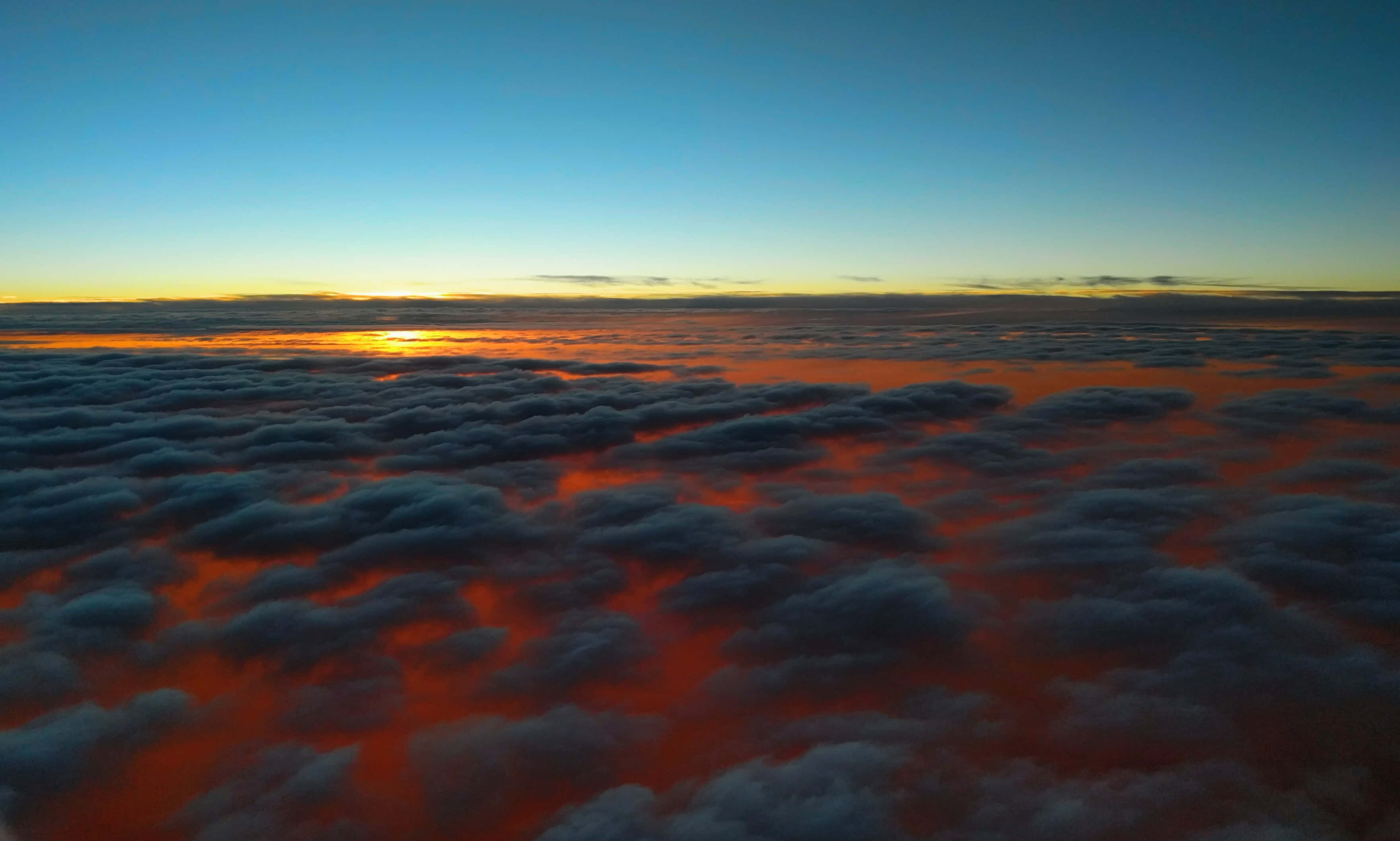 Clouds Aesthetics 桌布 壁紙 — 從空中視角，令人驚嘆的日出將雲海染成火橙色和深藍色。