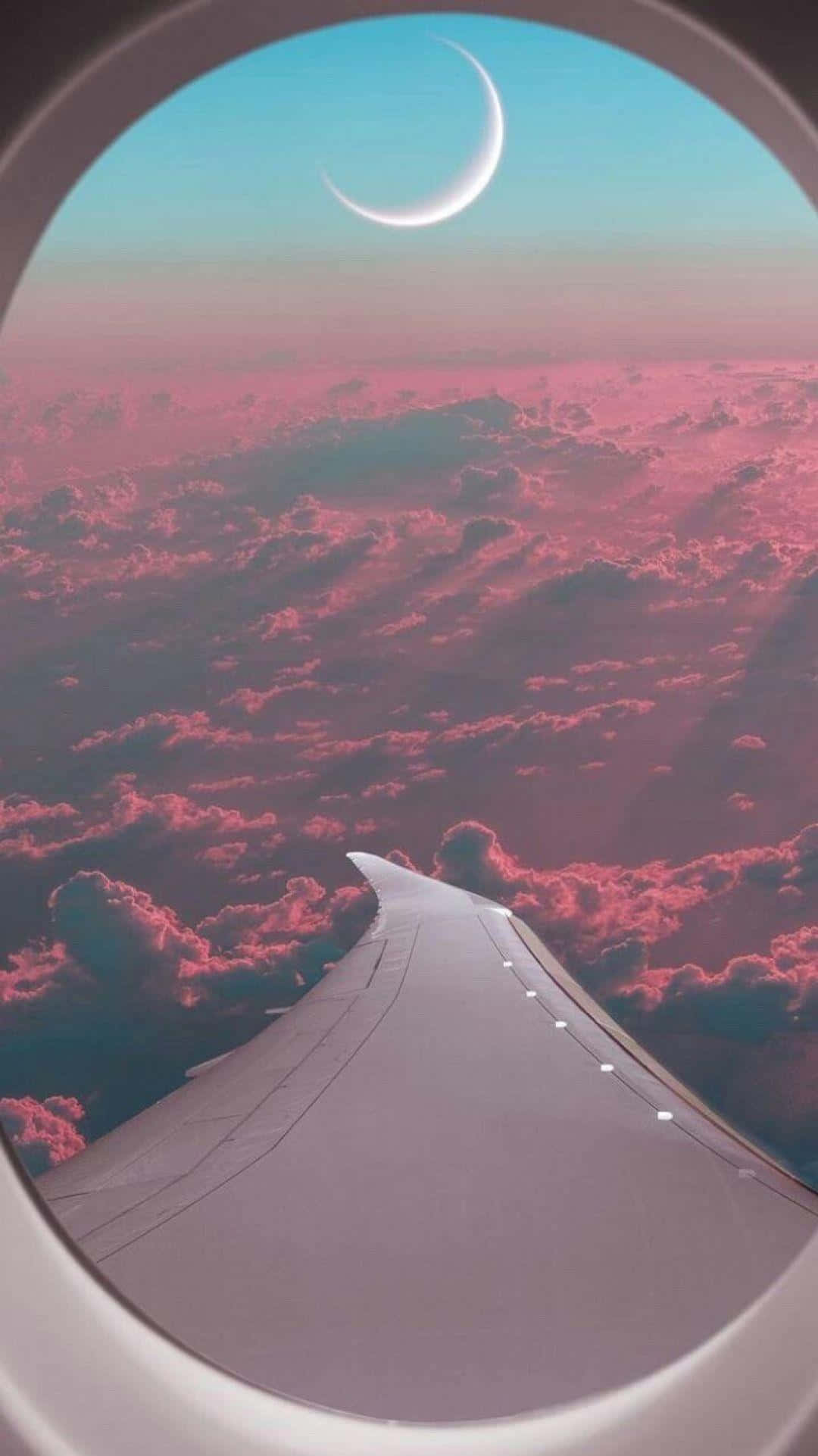Travel Aesthetic Phone 桌布 壁紙 — 從窗戶看到的飛機機翼，上方是粉紅色的雲朵和暮色天空中的新月。