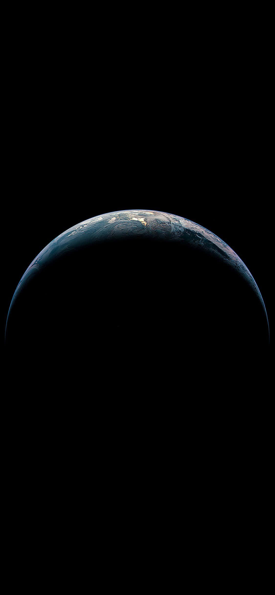 iPhone Earth 桌布 壁紙 — 從虛空中升起的地球的壯麗景色，沿著其彎曲的地平線，城市燈光閃爍，映襯著太空的漆黑。