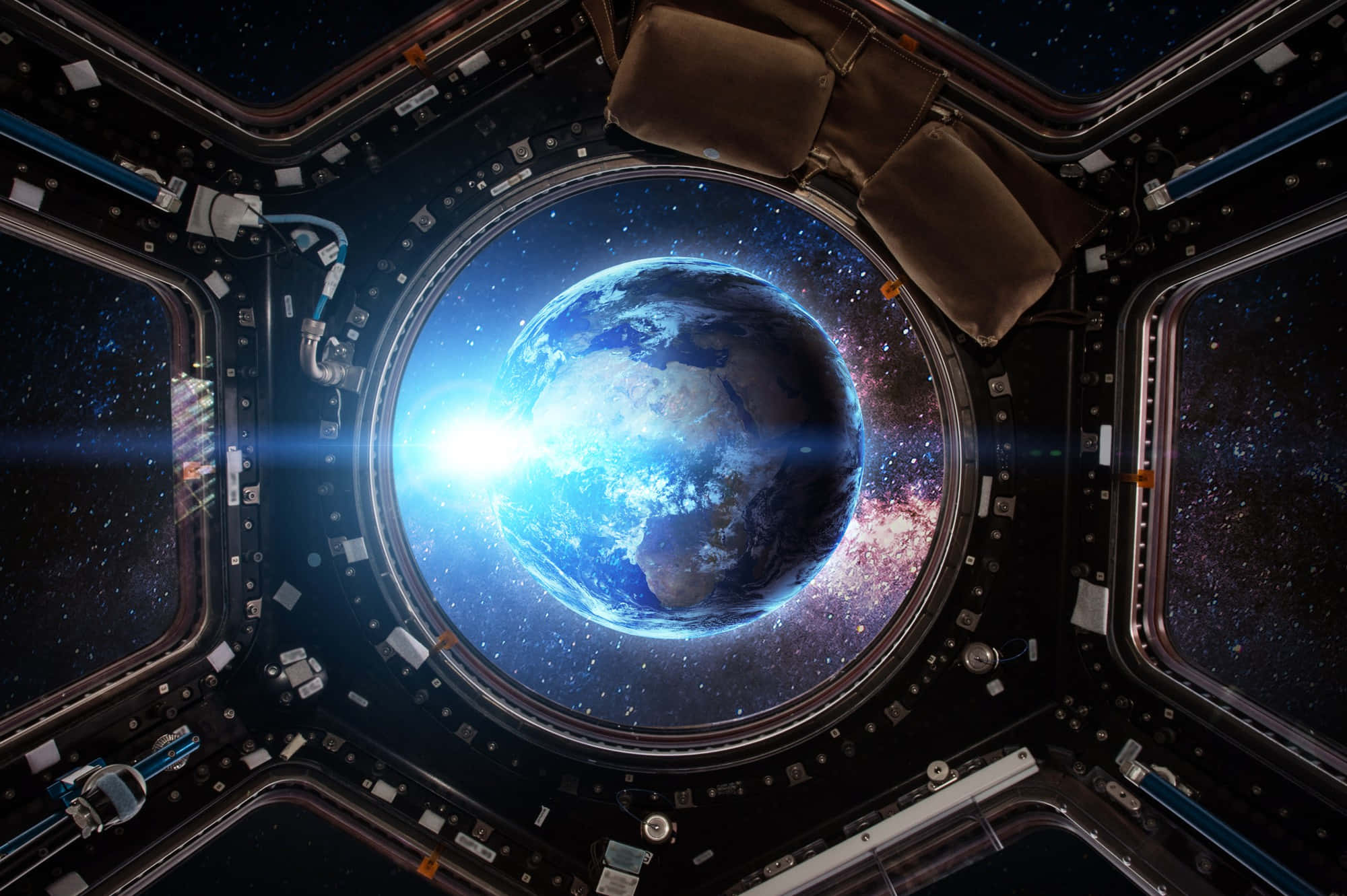 Space Technology 桌布 壁紙 — 從詳細的太空站模組內的圓形窗戶看到地球發出藍色光芒的絕美景觀。