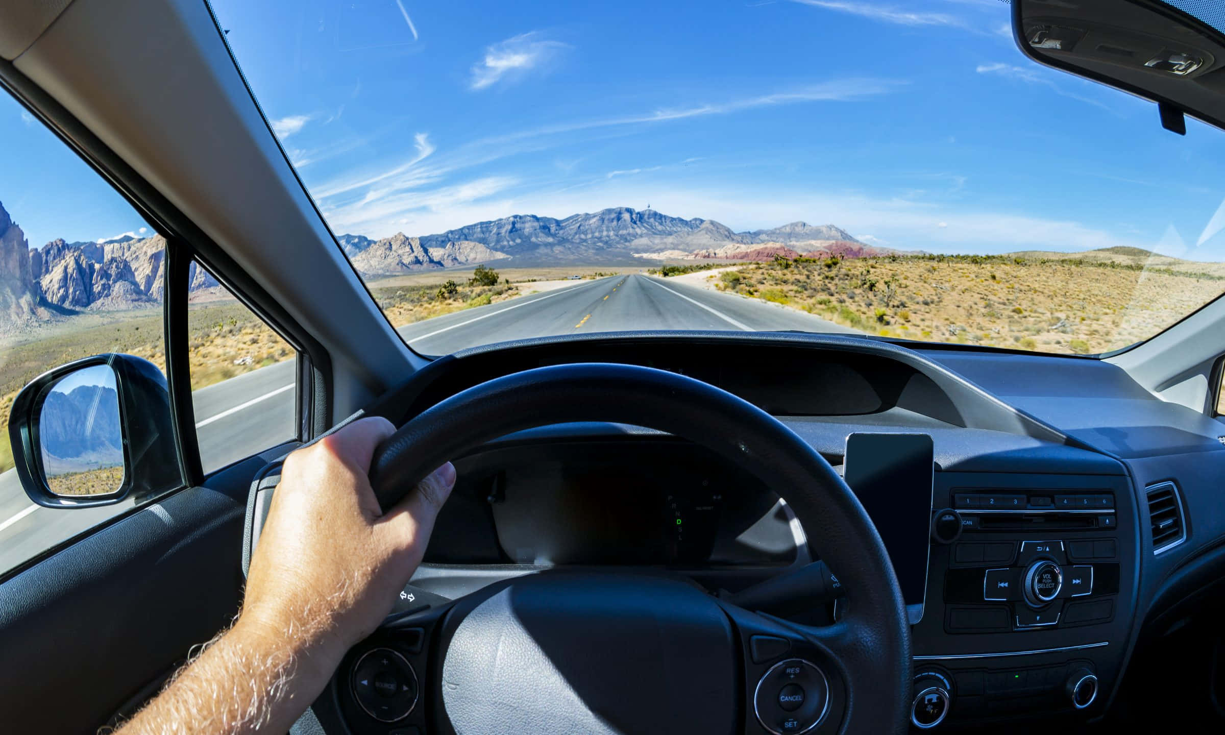 driving 桌布 壁紙 — 從車內第一人稱視角，沿著沙漠筆直公路駛向遠山，天空清澈湛藍。