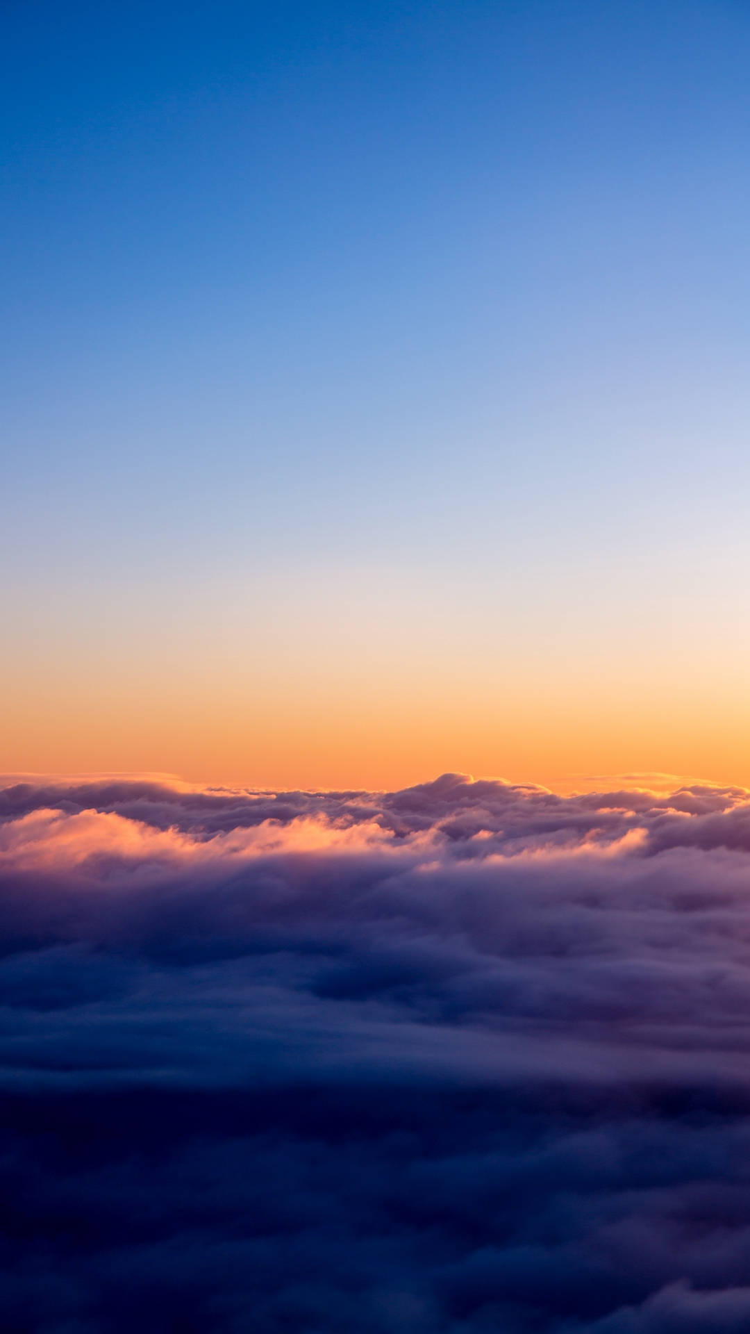 View 桌布 壁紙 — 從雲海之上俯瞰日出的壯麗景色，天空呈現鮮豔的橙色和藍色漸變。