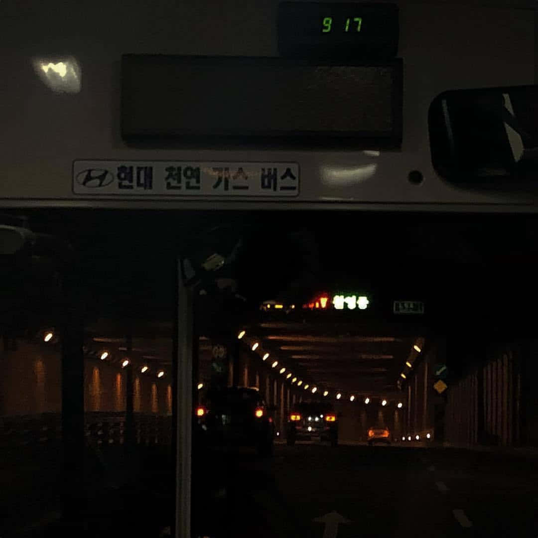 tunnel 桌布 壁紙 — 從韓國燃氣巴士內部觀看的夜景，顯示前方明亮的隧道、發光的車輛尾燈和顯示9點17分的數字時鐘。