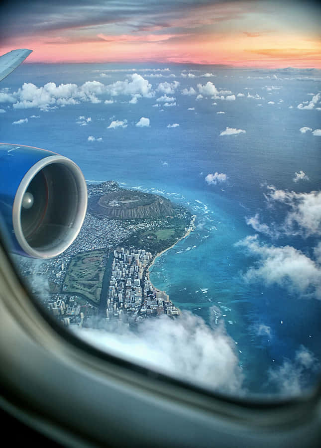 Airplane Window 桌布 壁紙 — 從飛機窗戶俯瞰檀香山歐胡島，鑽石頭山在日落時分，下方是充滿活力的藍色海洋。