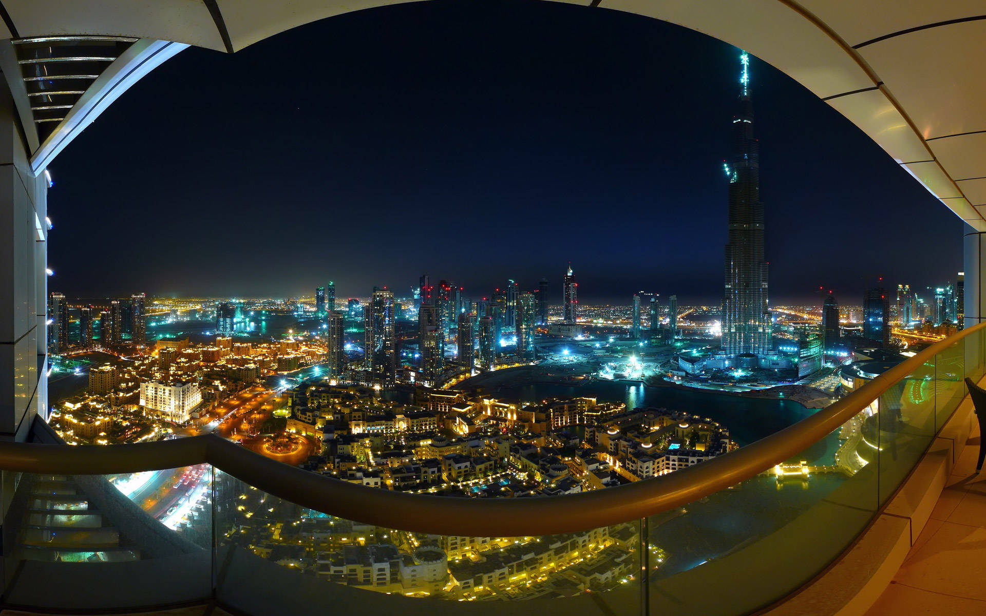 View 桌布 壁紙 — 從高層建築陽台的魚眼視角捕捉杜拜閃爍的夜景，以哈里發塔和發光的城市燈光為主導。