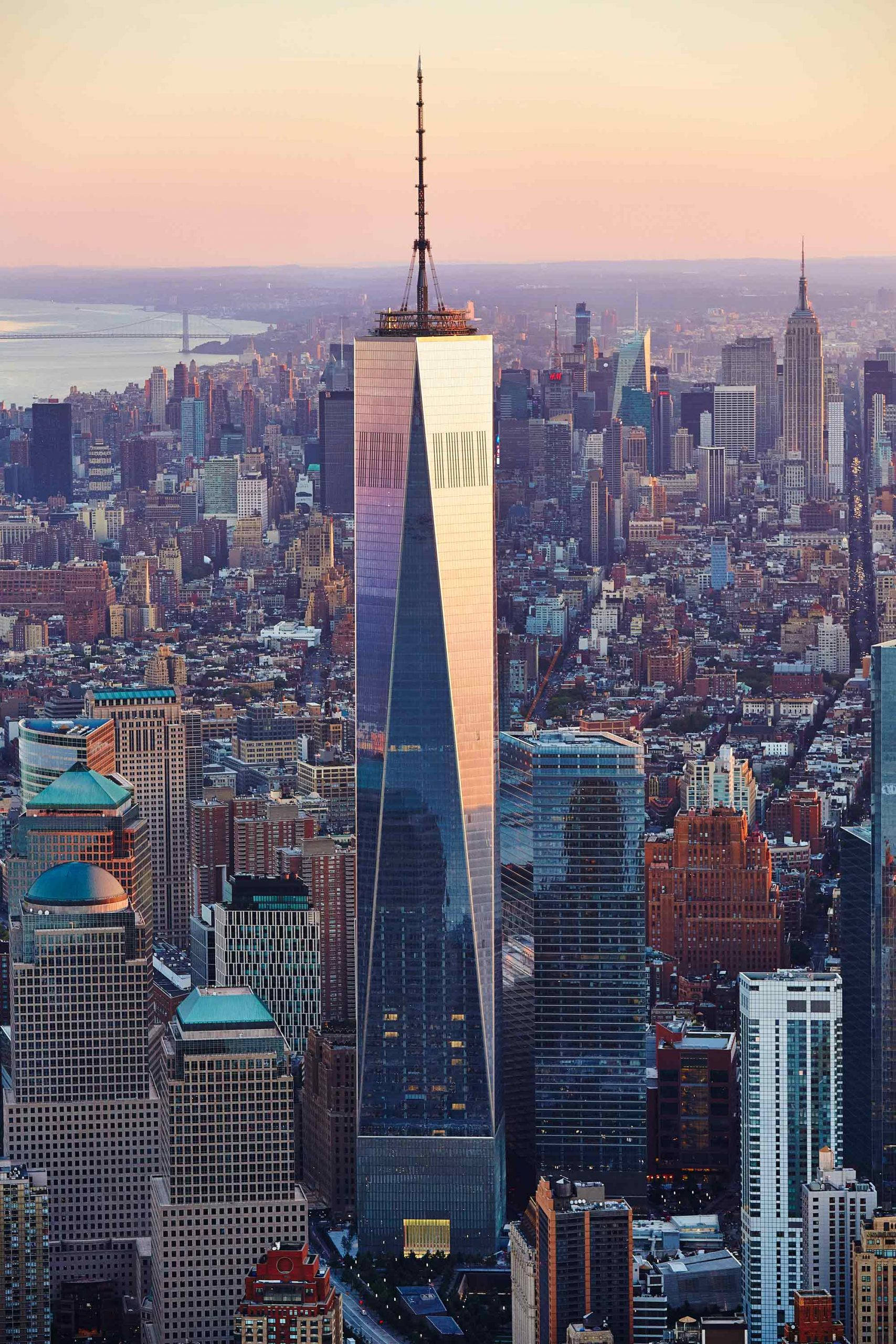 Building 桌布 壁紙 — 從高空俯瞰，世界貿易中心一號大樓在紐約市密集的天際線中於日落時分閃耀光芒。