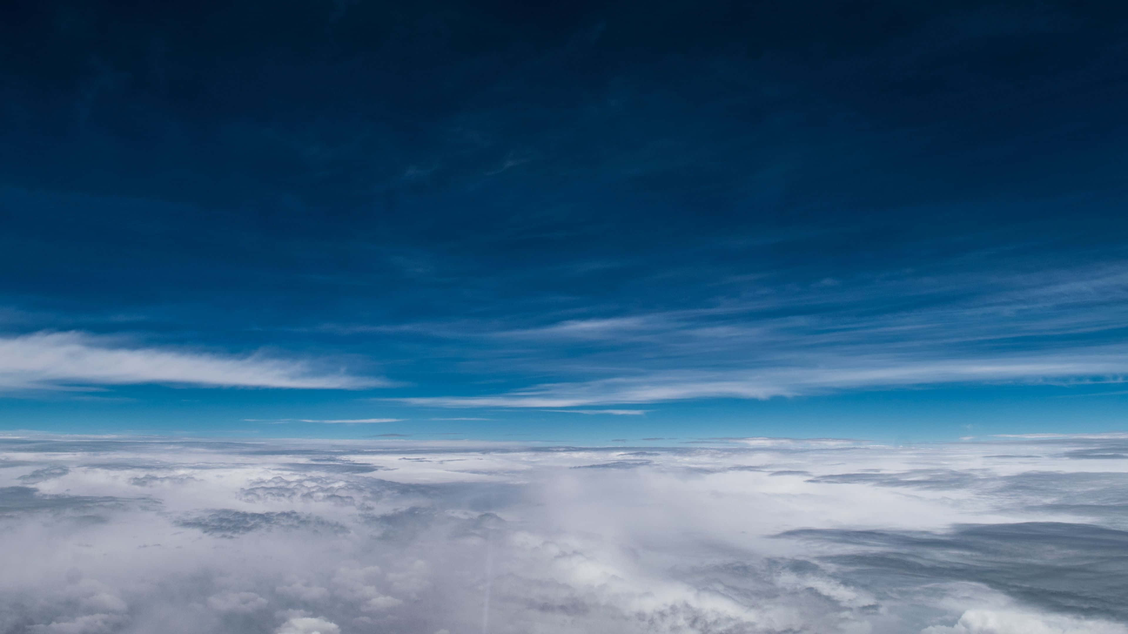 Atmosphere 桌布 壁紙 — 從高空俯瞰，在廣闊漸變藍天下翱翔於無盡白雲之上。