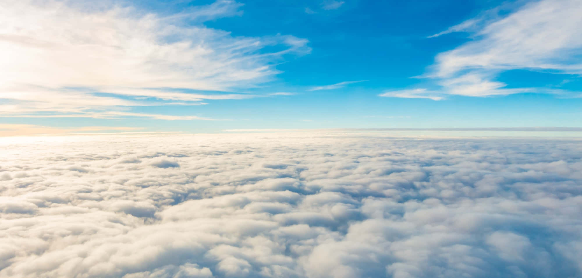 Sky Clouds 桌布 壁紙 — 從高空俯瞰，在日出時分，廣闊清澈的藍天下，翱翔於無盡的棉花糖雲層之上。