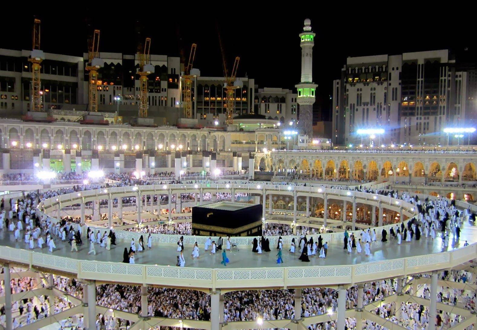 Makkah 桌布 壁紙 — 從高空俯瞰，朝聖者在麥加天房周圍繞行，夜晚燈火通明，建築起重機清晰可見。
