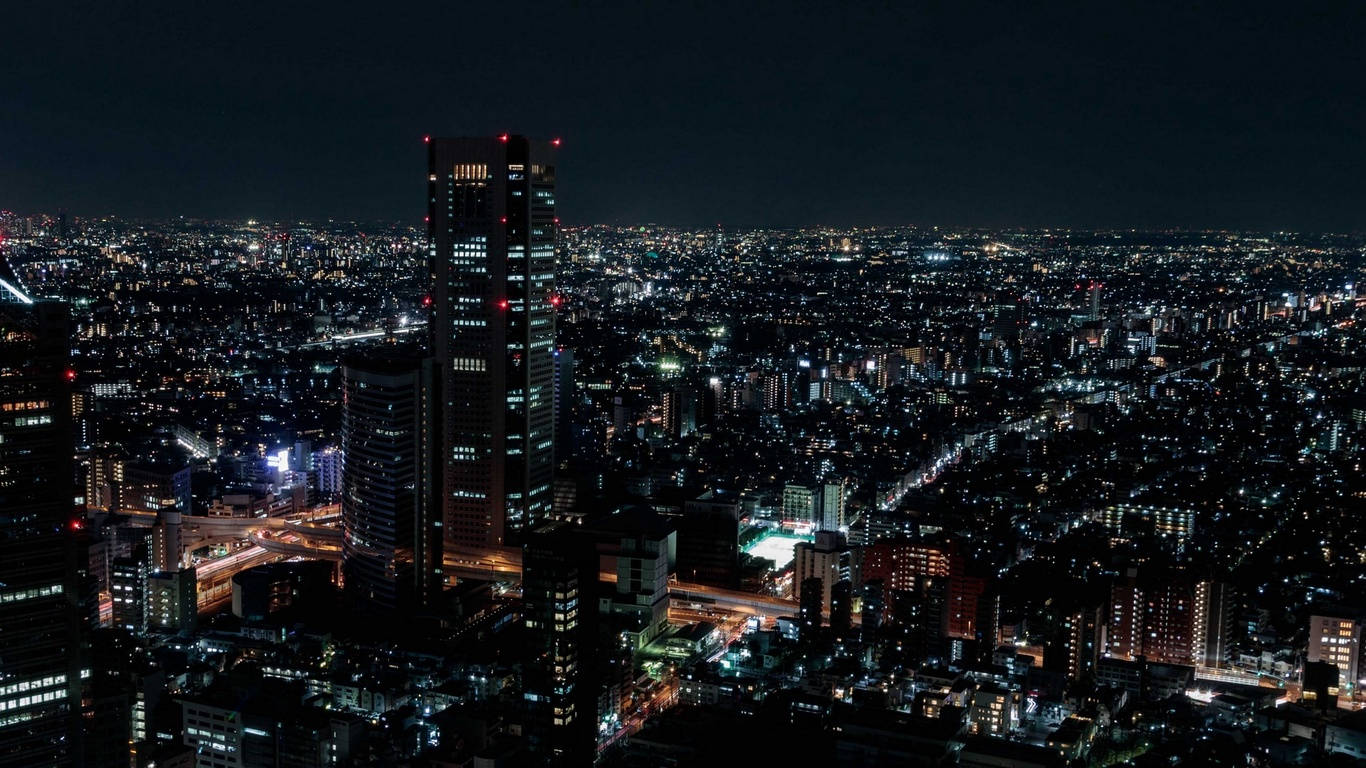 Anime Night City 桌布 壁紙 — 從高空俯瞰，無數發光的窗戶和街燈照亮了廣闊的城市景觀的夜景。