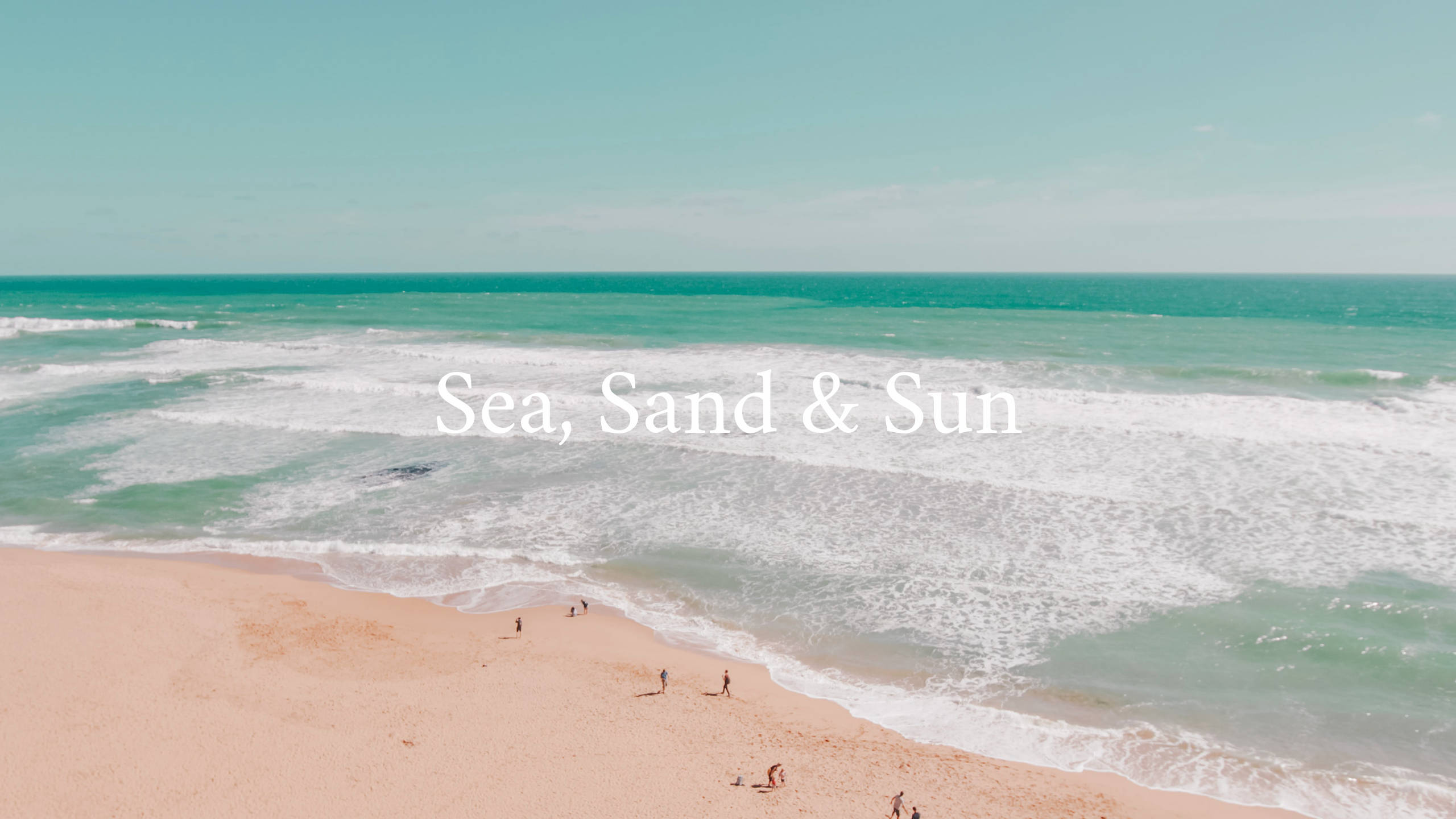 海灘 桌布 壁紙 — 從高空俯瞰，碧綠的海浪拍打著金色的沙灘，沙灘上散落著遊客，天空晴朗。