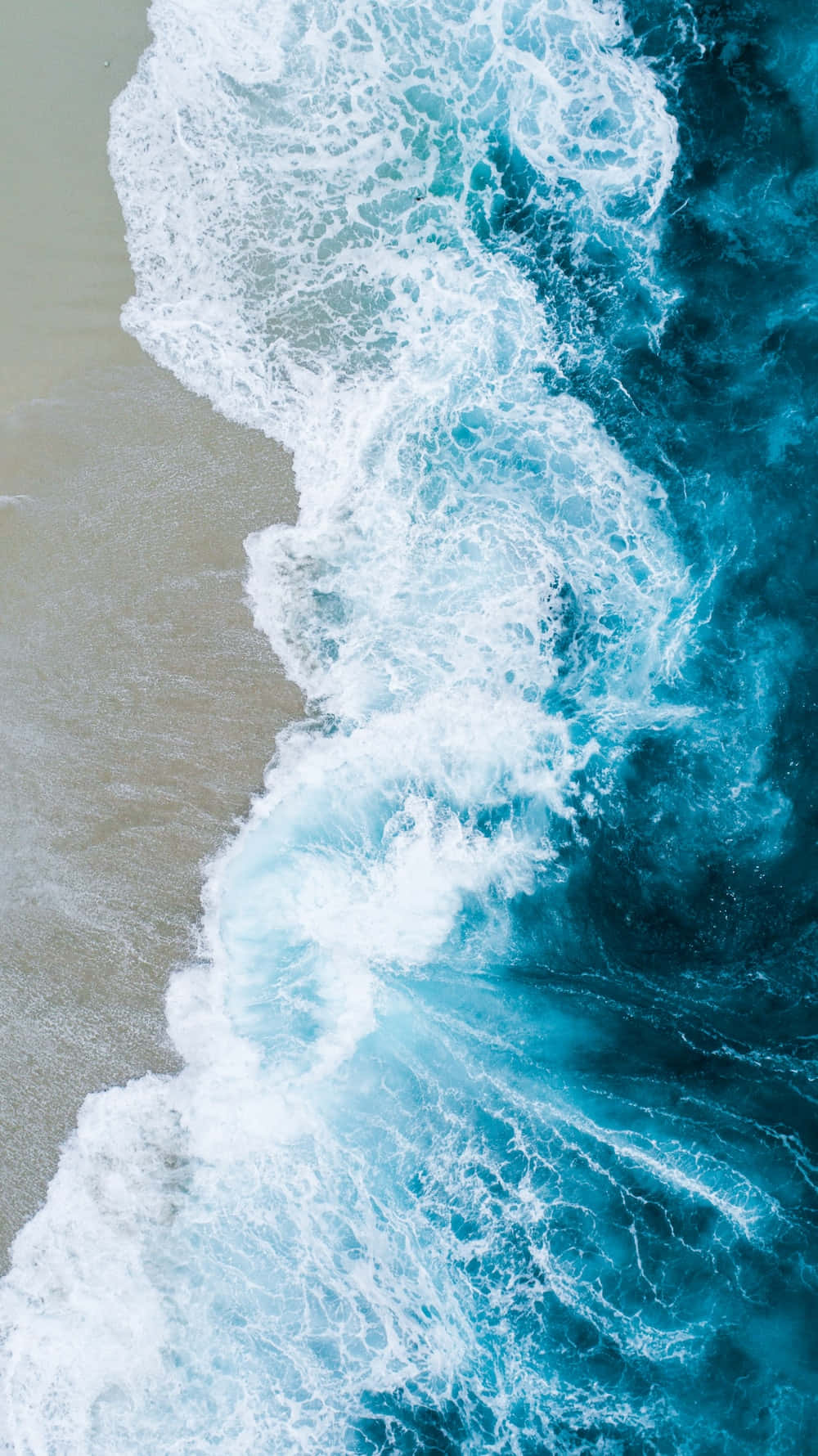 海洋 桌布 壁紙 — 從高空俯瞰，碧綠色的海浪拍打沙灘，激起白色泡沫般的浪花。