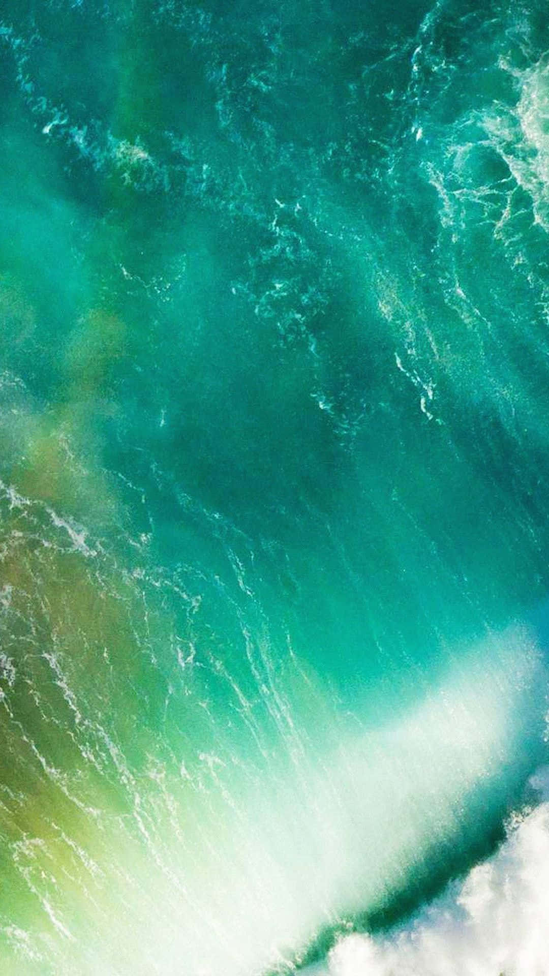 iPhone 桌布 壁紙 — 從高空俯瞰，綠松石色的海浪拍打岩石海岸，激起白色泡沫。