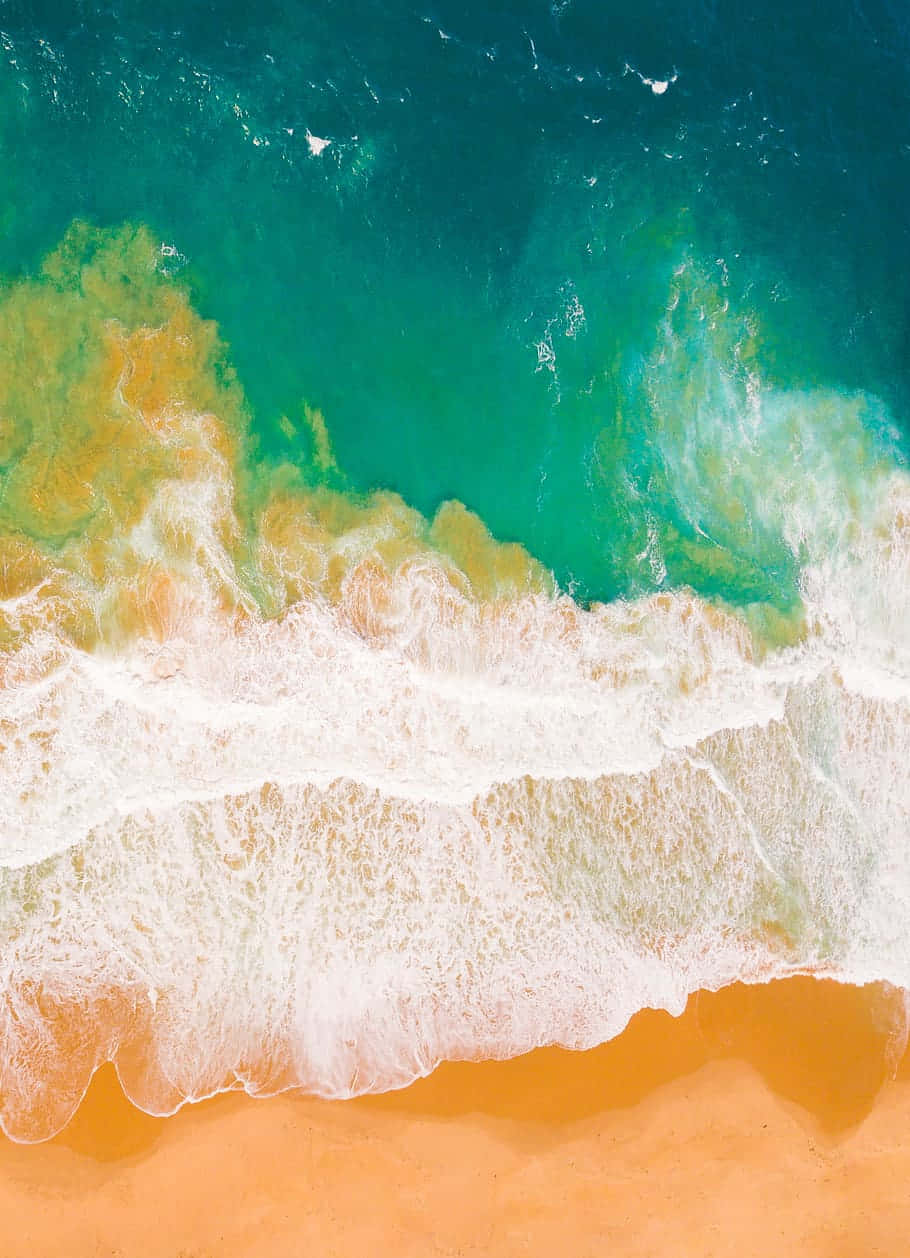 Minimalist Beach 桌布 壁紙 — 從高空俯瞰，綠松石色的海浪拍打著金色沙灘，泛起白色泡沫。