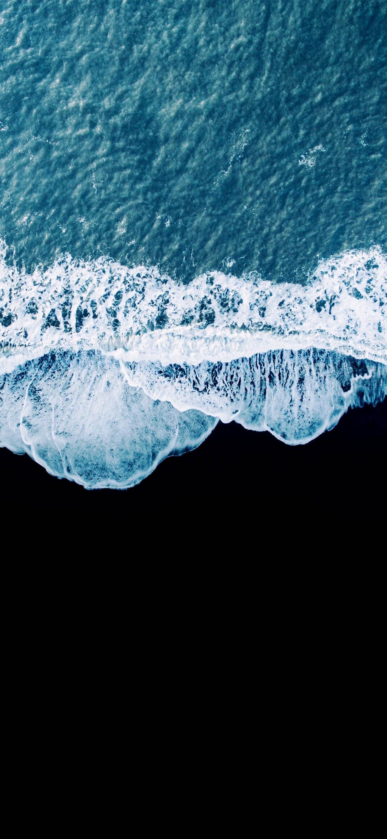 waves 桌布 壁紙 — 從高空俯瞰，綠松石色的海浪拍打黑色海岸，泛起白色泡沫。