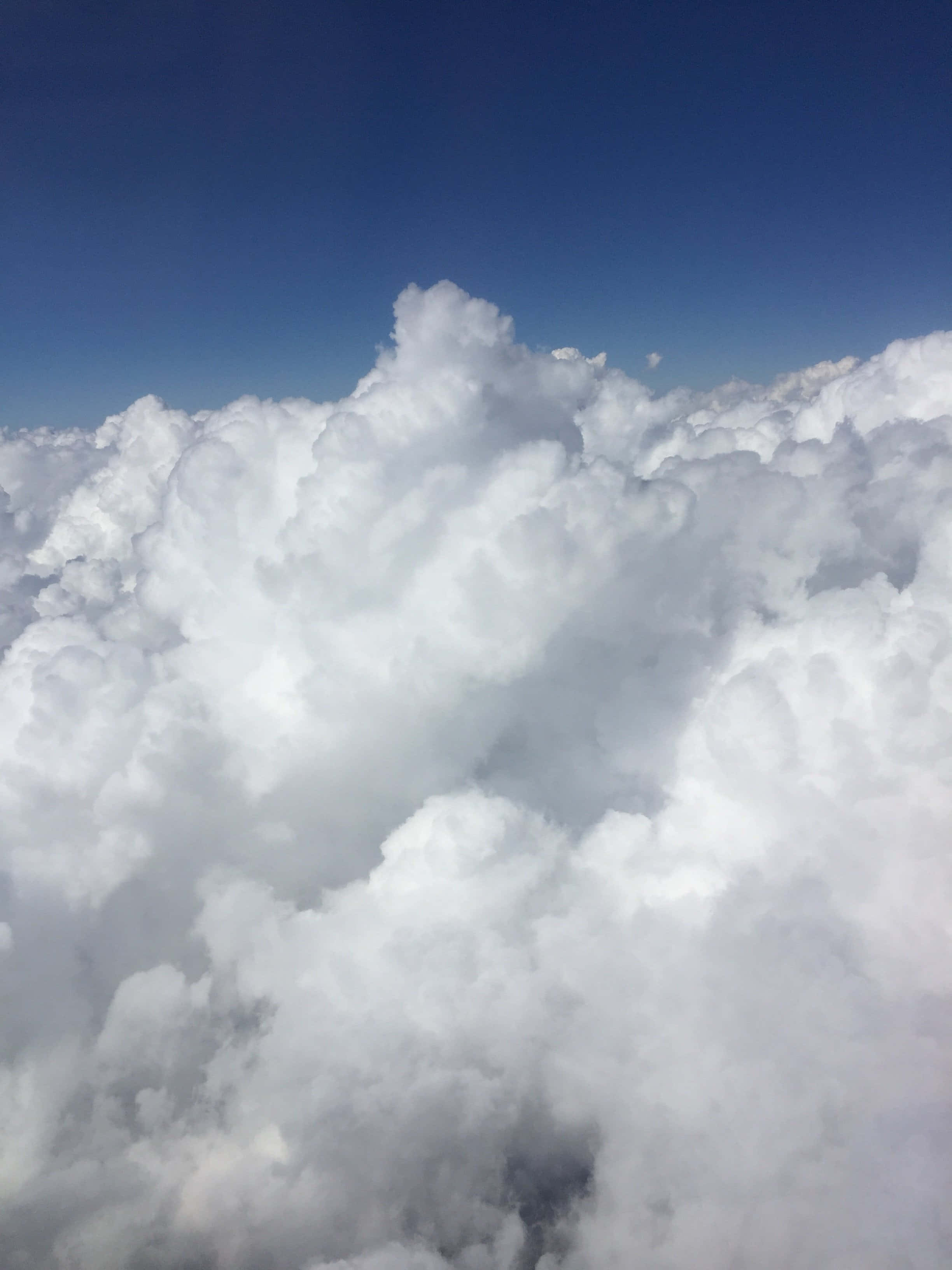 White Cloud 桌布 壁紙 — 從高空俯瞰，蓬鬆的白雲在清澈深藍的天空下延伸。